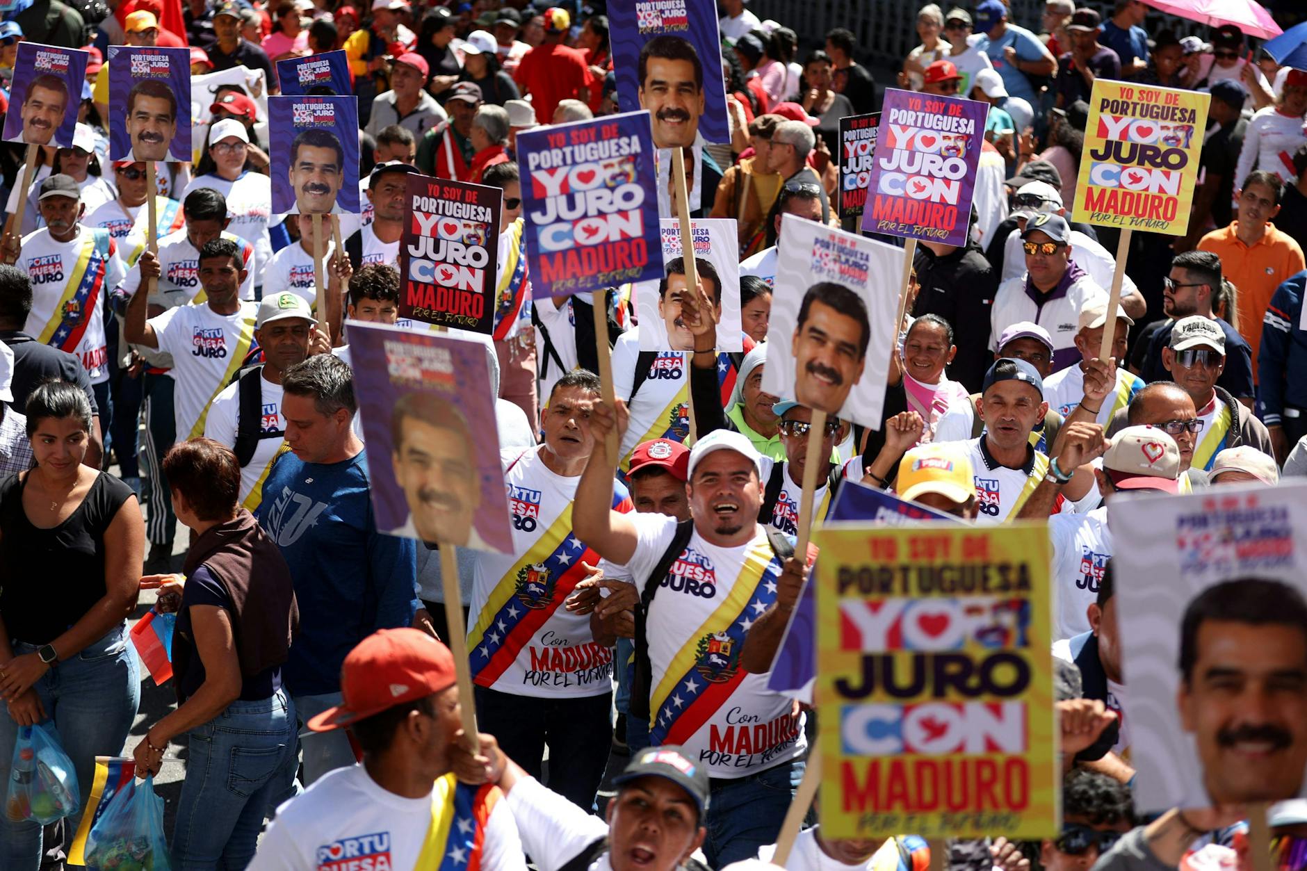 Anhänger des venezolanischen Präsidenten Nicolás Maduro halten Schilder hoch und rufen Slogans.