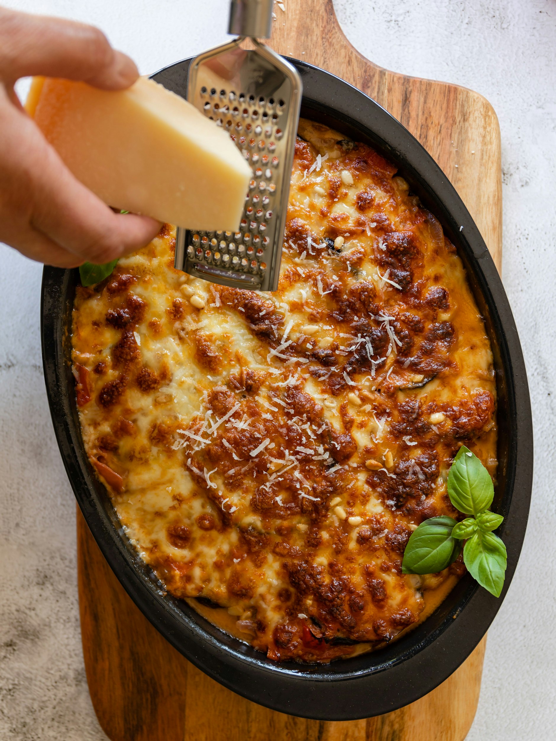 Wer es besonders würzig mag, gibt noch etwas geriebenen Käse über die Moussaka.