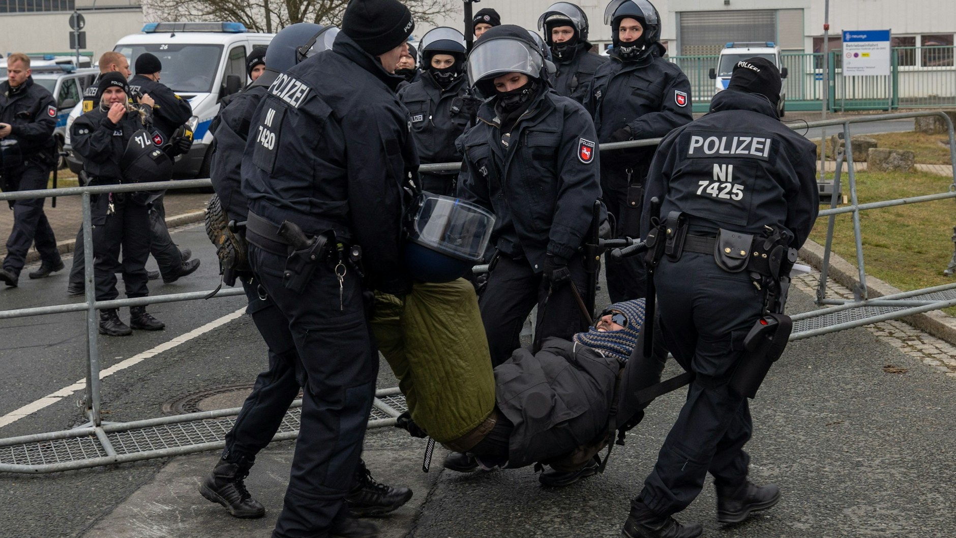 Polizisten tragen Demonstranten von der Straße, die mit einer Sitzblockade Zufahrten zur WT Energiesysteme Arena Riesa versperren.