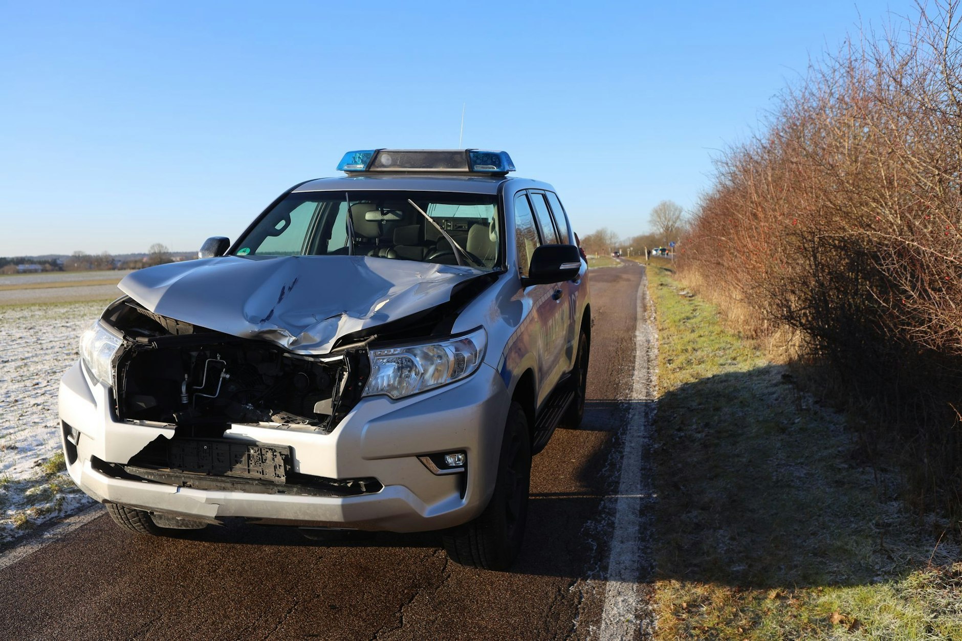 Das beschädigte Fahrzeug der Militärpolizei steht nach einem Unfall auf einem Fußweg neben der B14.