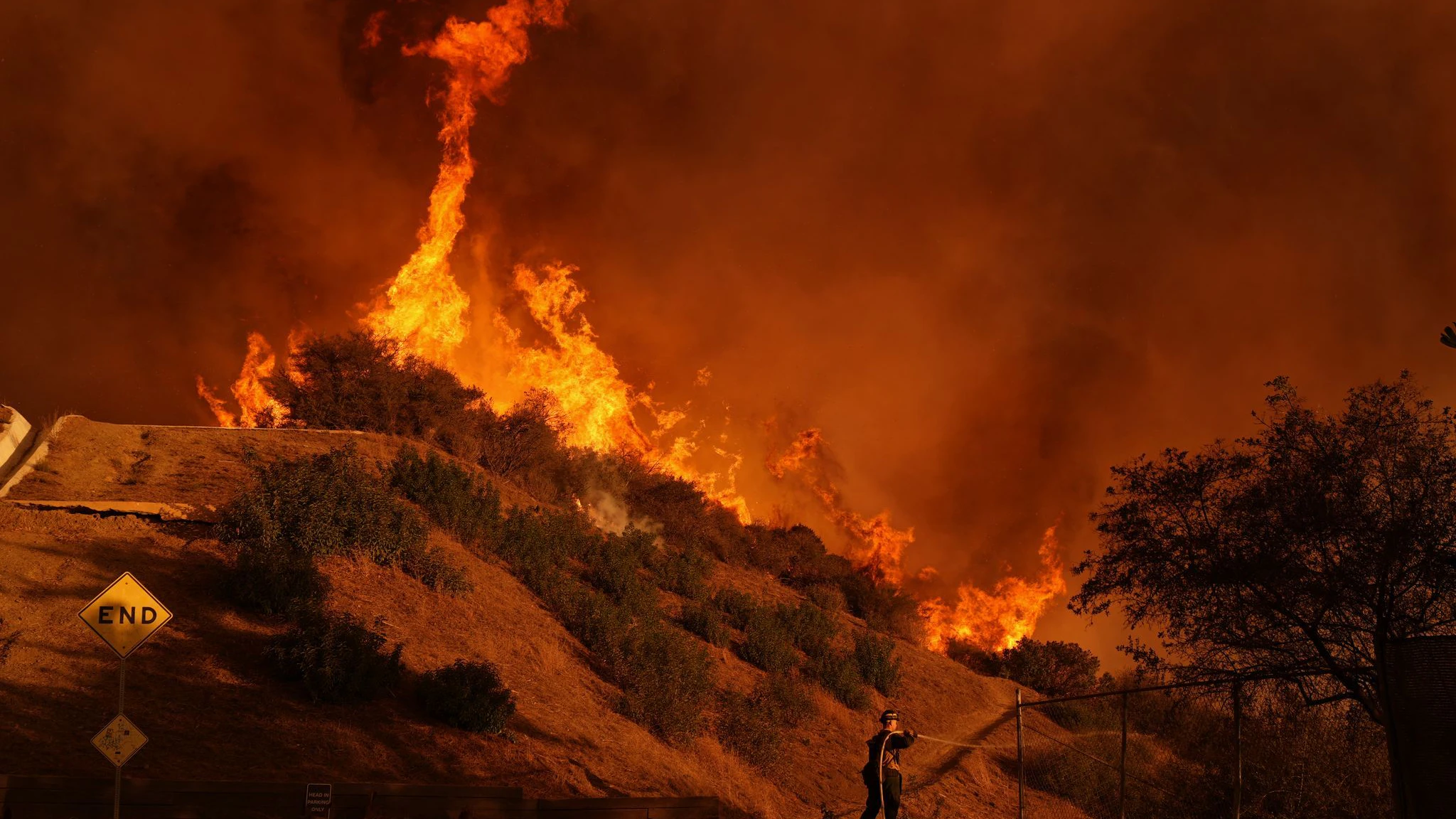 Ein Feuerwehrmann bekämpft das Palisades-Feuer im Mandeville Canyon.
