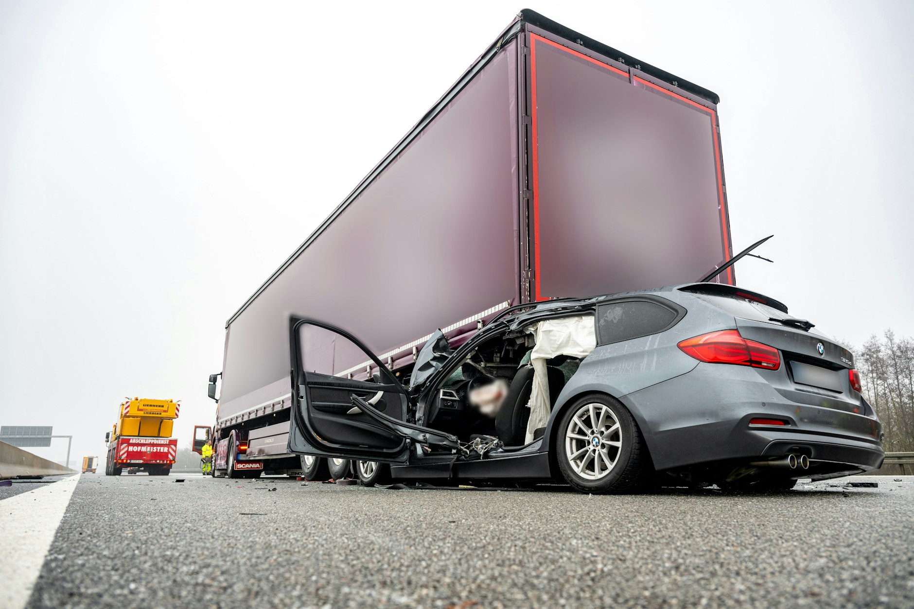 Ein zerstörtes Fahrzeug steht auf der Autobahn A3 bei Regensburg. Bei einer Serie von Unfällen auf eisglatter Straße ist auf der Autobahn ein Mensch gestorben.