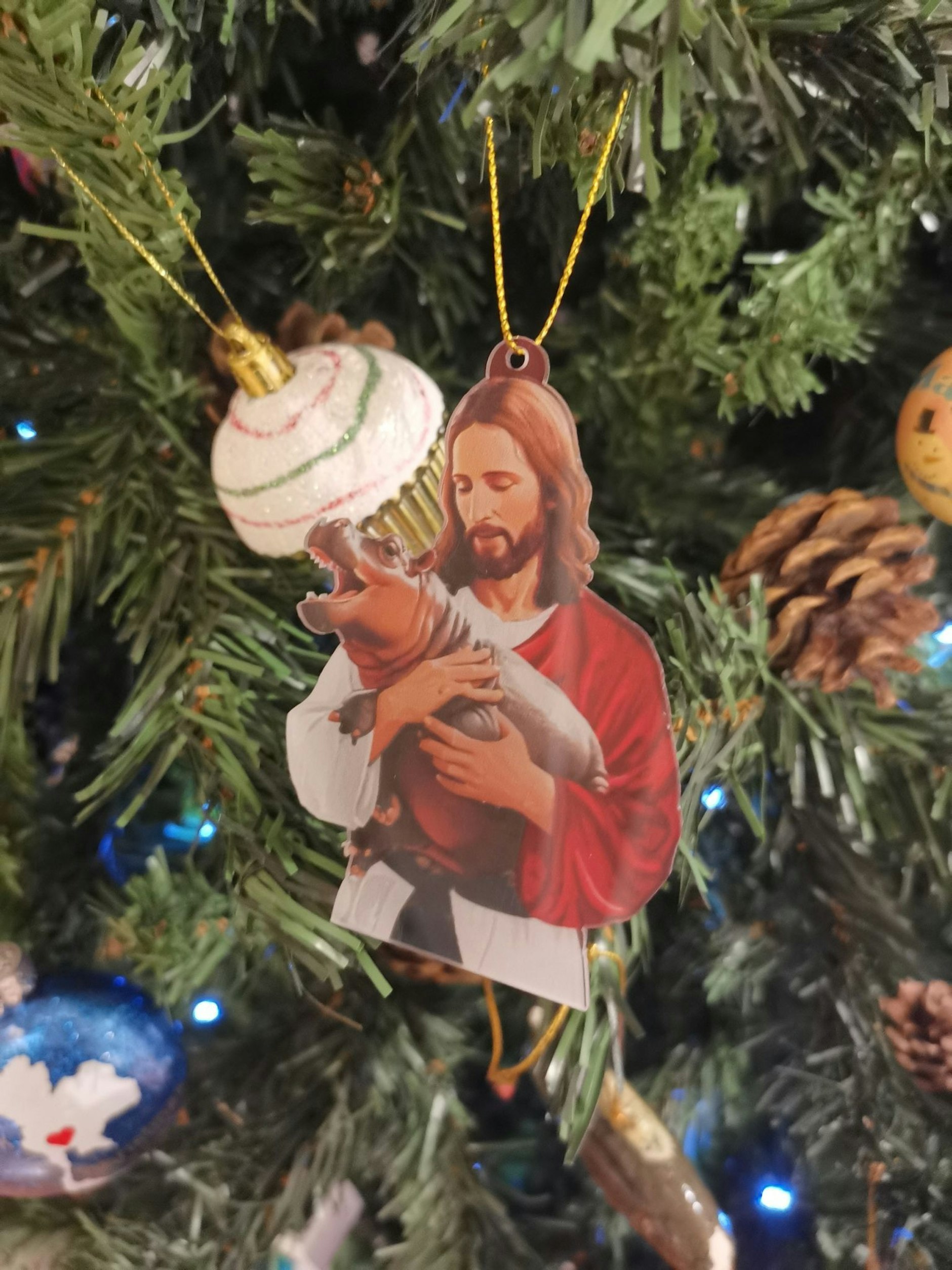 Eine Christbaum-Dekoration zeigt Jesus mit dem Zwerghippo Moo Deng.