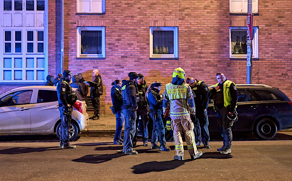 Polizisten stehen in der Nähe des Tatortes. 