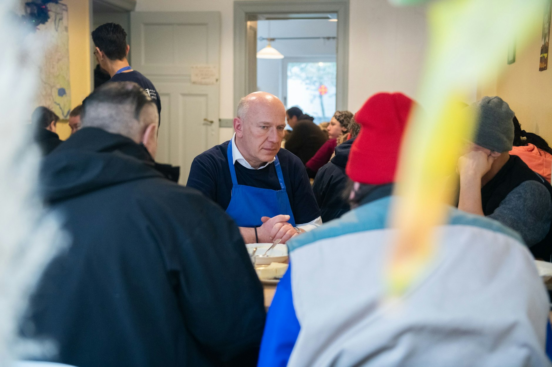 Berlins Regierender Bürgermeister Kai Wegner im Gespräch mit den Gästen der Tee- und Wärmestube Neukölln.