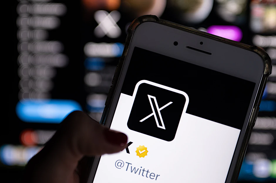 Auf dem offiziellen Profil von Twitter auf dem Bildschirm eines Smartphones ist der weiße Buchstabe X auf schwarzem Hintergrund zu sehen.