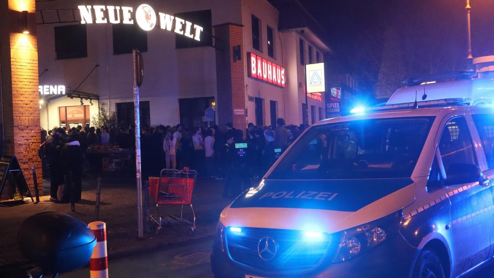 Die Polizei vor der Konzerthalle in Neukölln, die Besucher stehen davor, die nach der Reizgasattacke das Gebäude verlassen mussten.