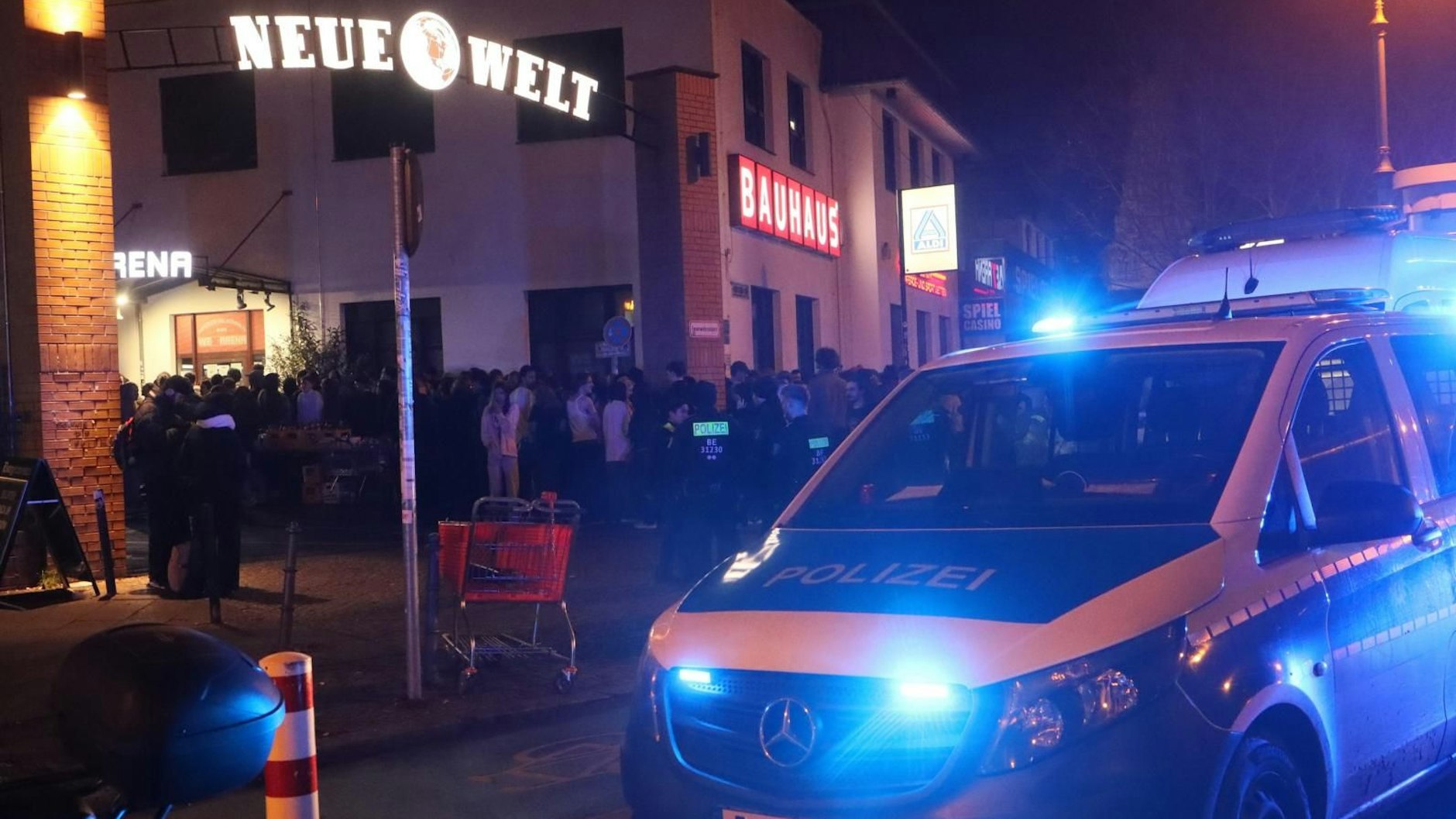 Die Polizei vor der Konzerthalle in Neukölln, die Besucher stehen davor, die nach der Reizgasattacke das Gebäude verlassen mussten.