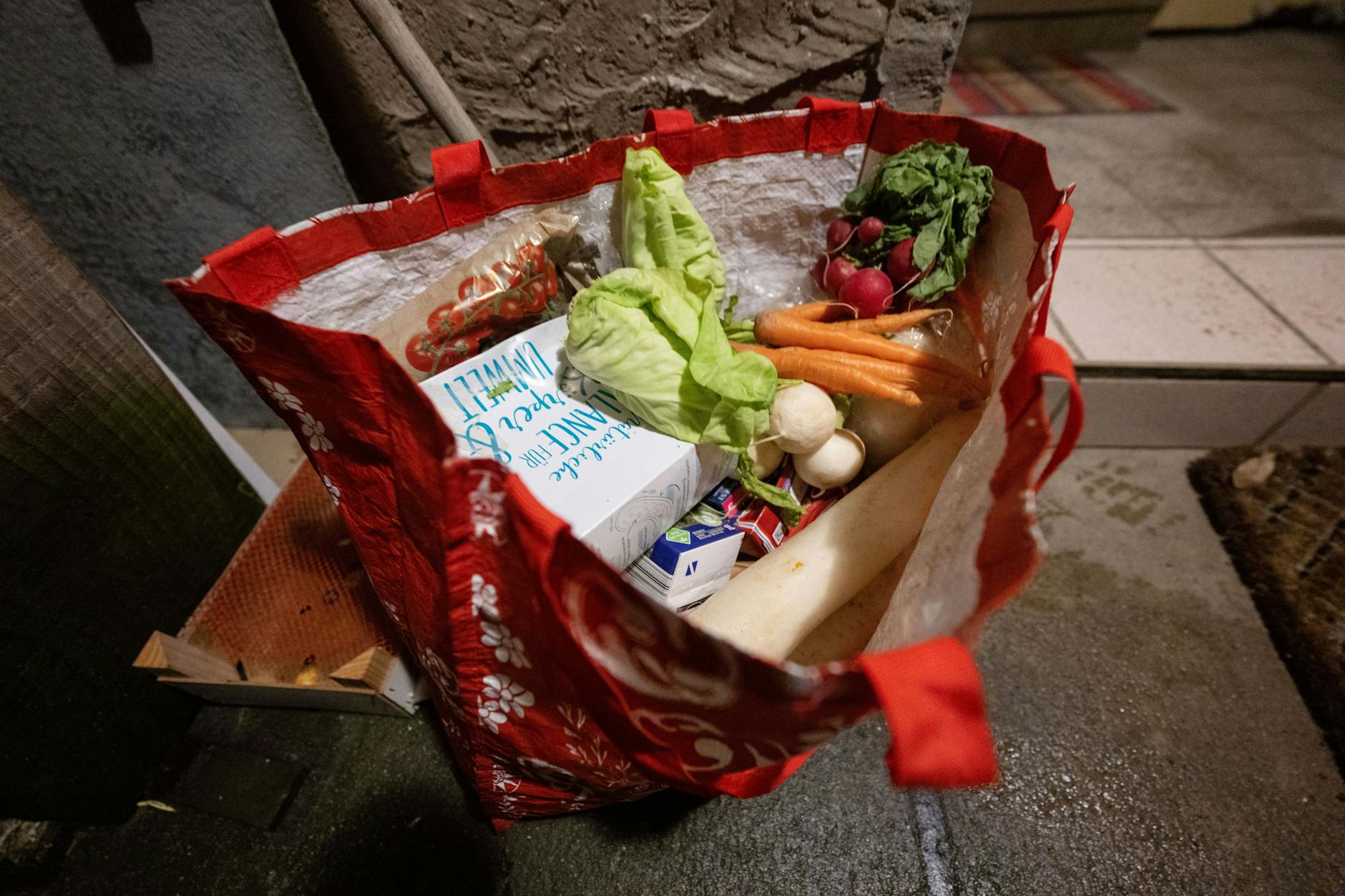 Eine Tasche voller Lebensmittel, die aus Abfalleimern eines Supermarktes im Großraum Stuttgart stammen, steht am Eingang eines Hauses.