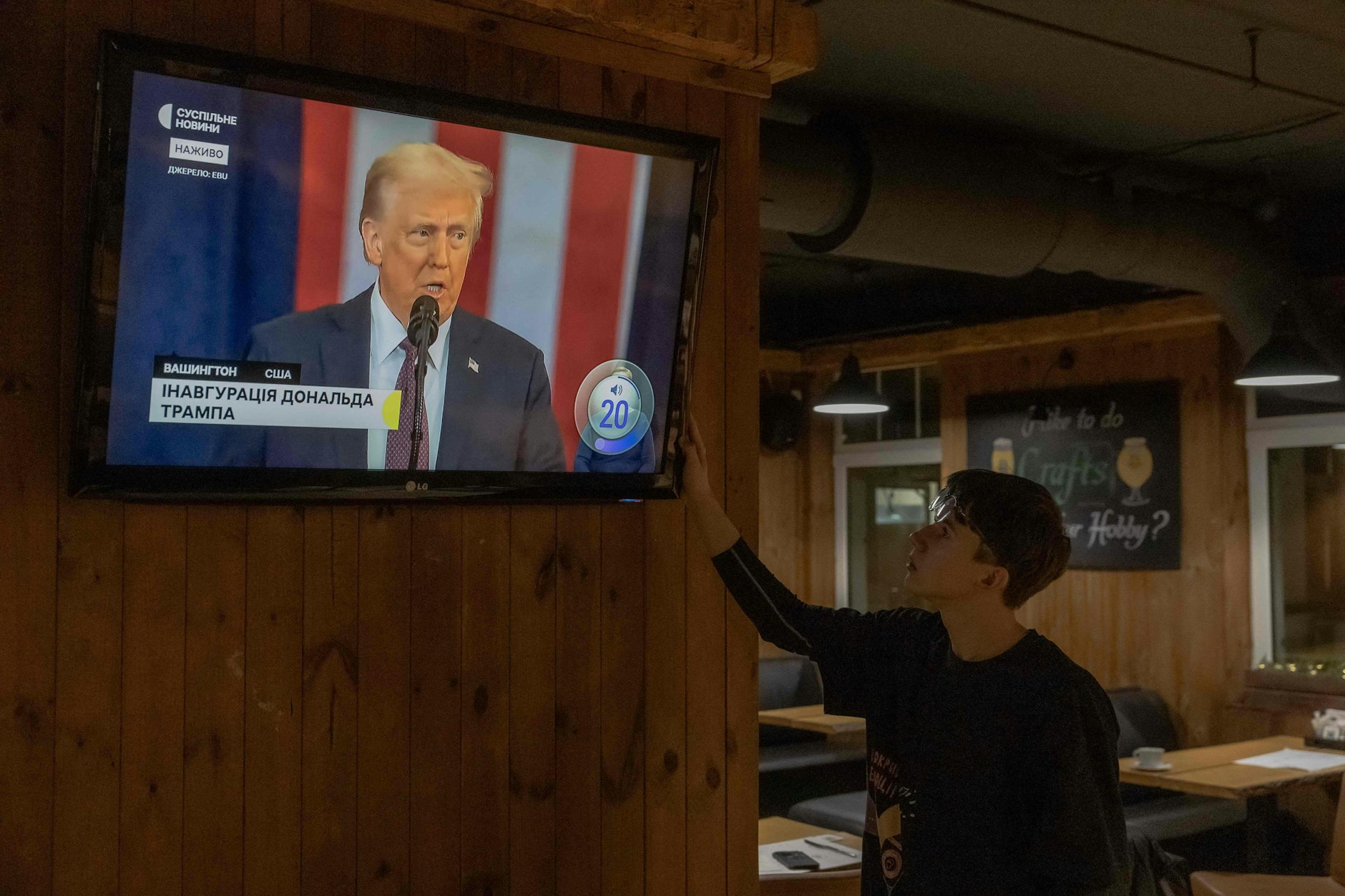 Ein Mitarbeiter in einem Kiewer Restaurant verfolgt auf einem Fernseher die Amtseinführung von US-Präsident Donald Trump