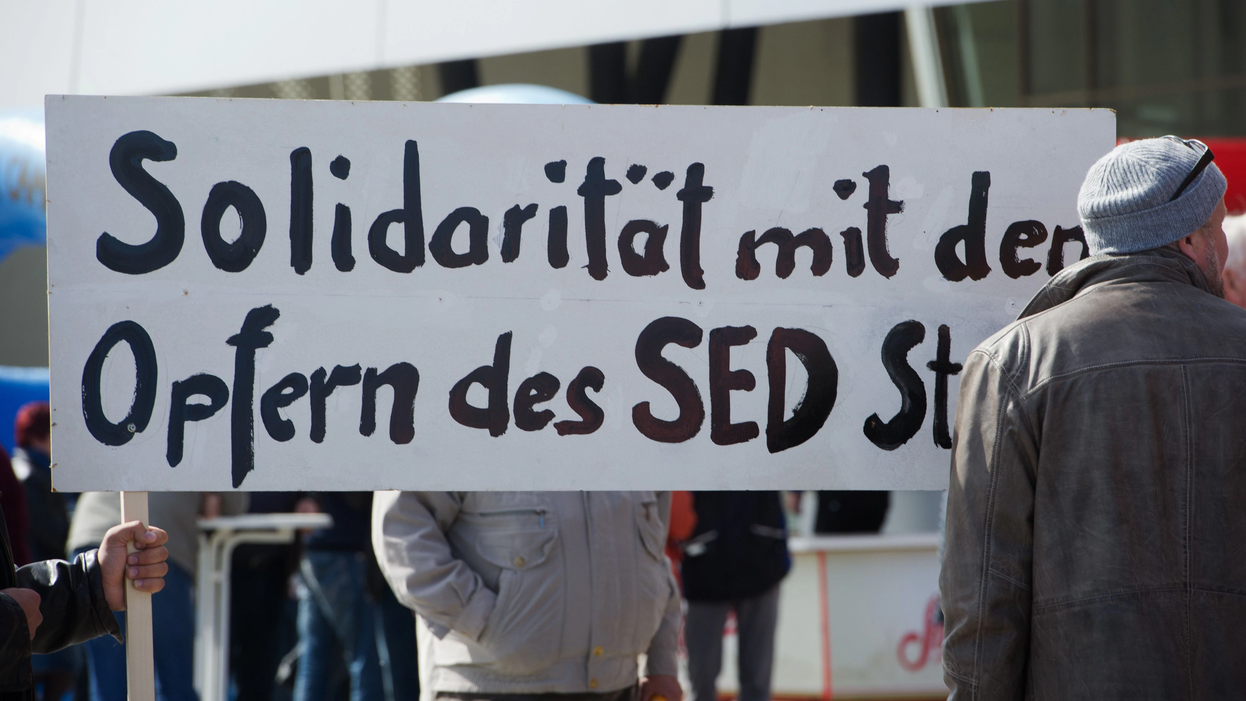 Seit Jahren kämpfen sie um mehr Anerkennung: Gier halten Demonstranten bei einer 1. Mai-Kundgebung in Stralsund ein Schild mit der Aufschrift „Solidarität mit den Opfern des SED-Staates“ hoch.