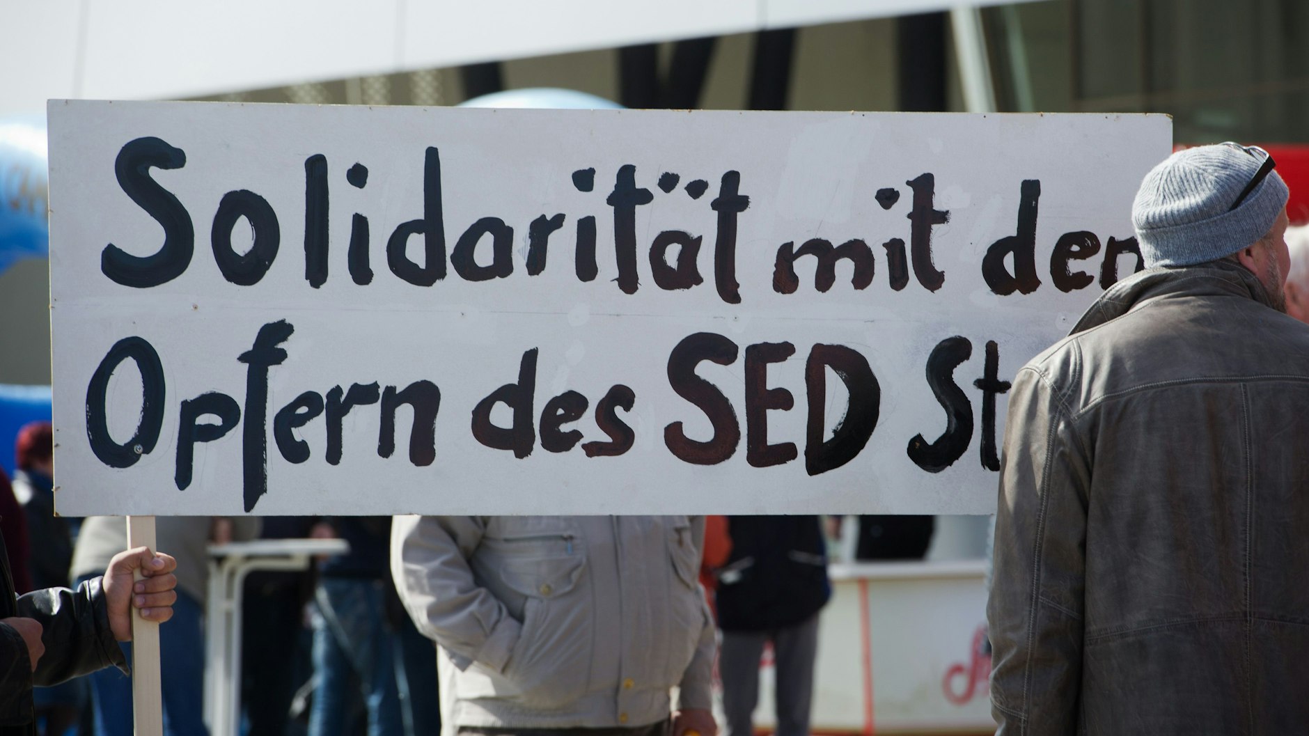 Seit Jahren kämpfen sie um mehr Anerkennung: Gier halten Demonstranten bei einer 1. Mai-Kundgebung in Stralsund ein Schild mit der Aufschrift „Solidarität mit den Opfern des SED-Staates“ hoch.