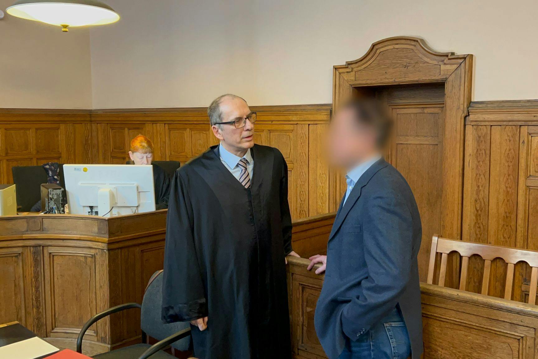 Der angeklagte Lehrer (r.) steht mit seinem Anwalt Uwe Freyschmidt im Gerichtssaal. Der 62-Jährige ist wegen Körperverletzung im Amt angeklagt.