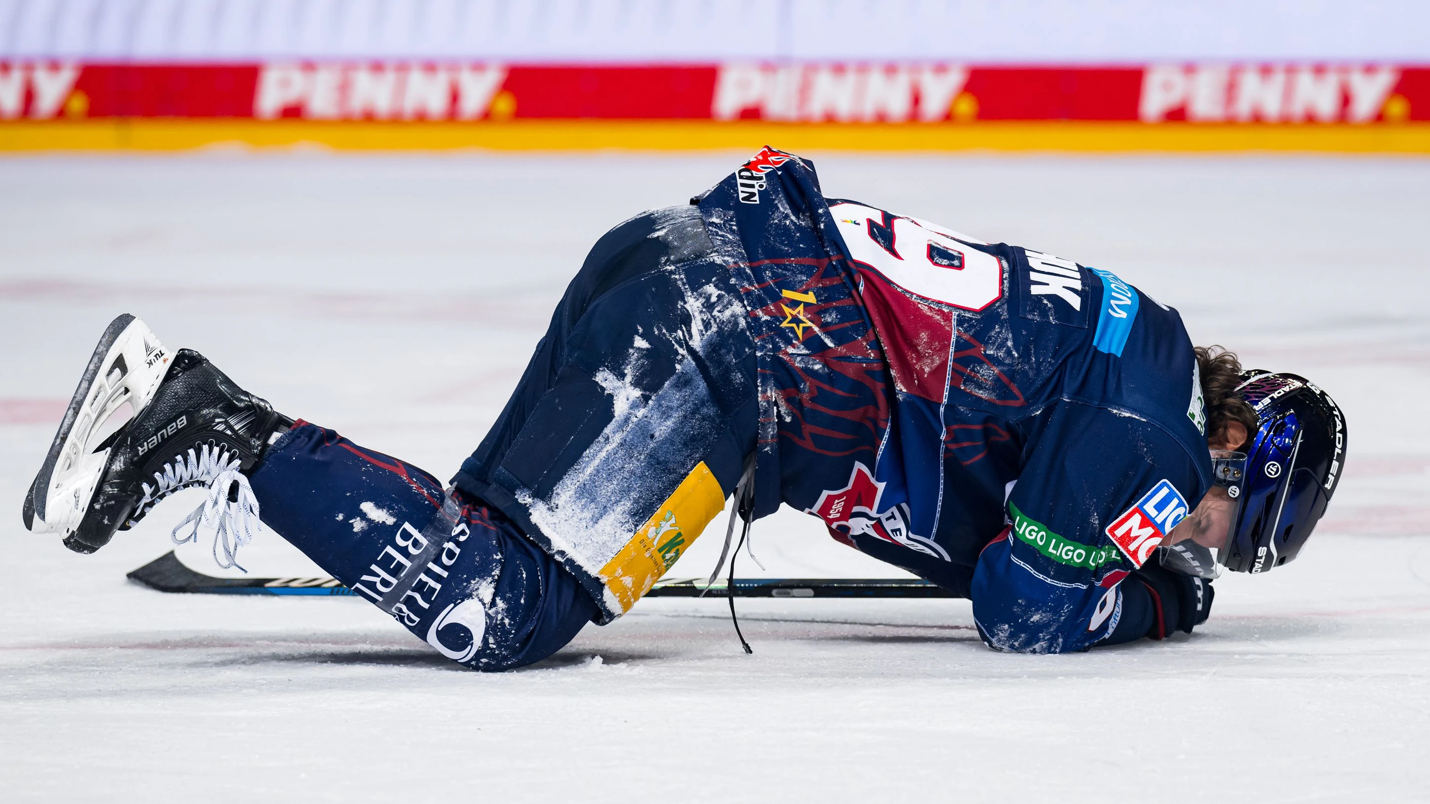 Eisbär Zach Boychuk liegt nach dem fiesen Check eines Bremerhavener Spielers auf dem Eis.