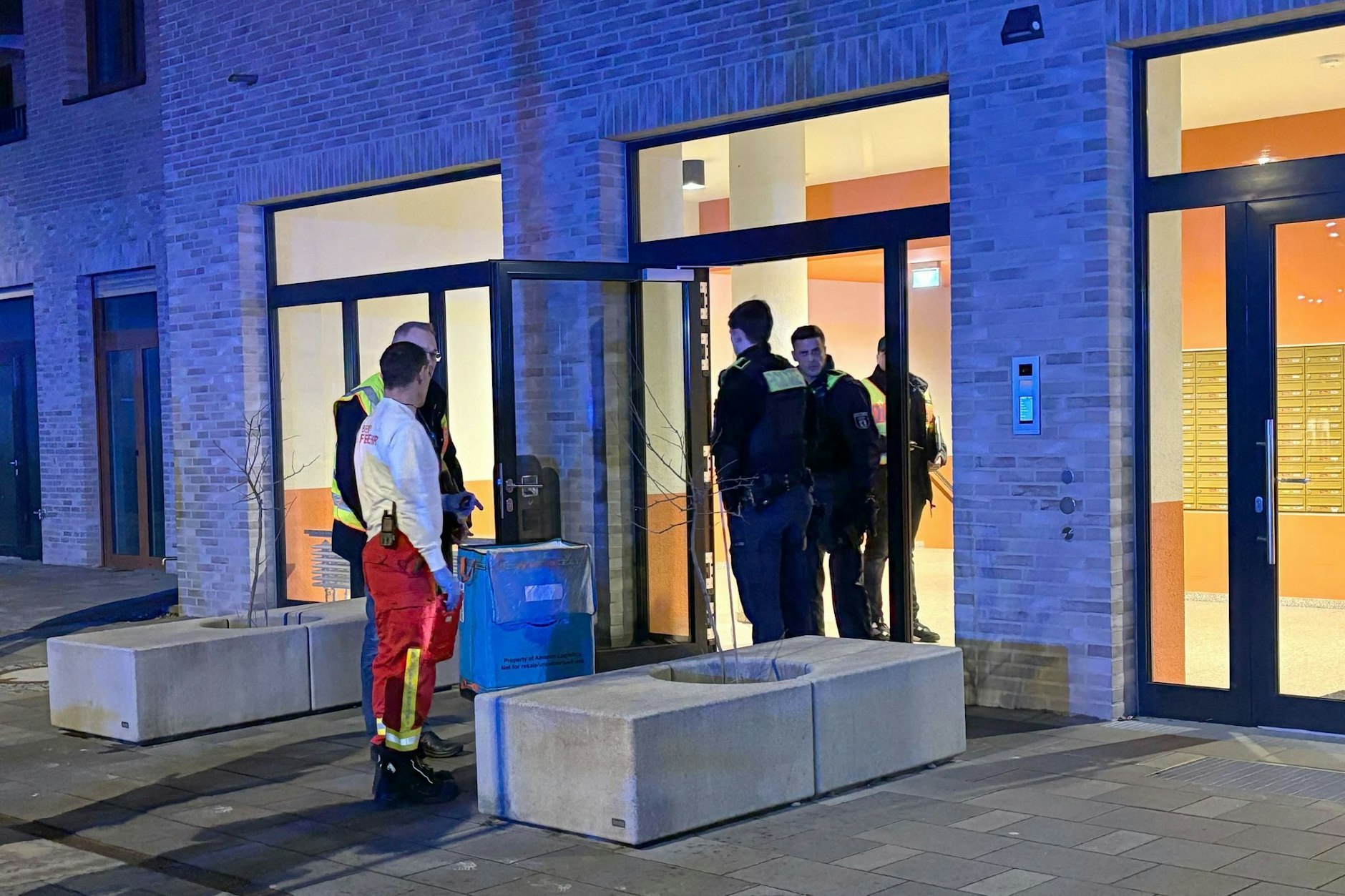 Einsatz- und Rettungskräfte stehen in Marzahn vor einem Haus. Ein 59 Jahre alter Mann ist in dem Haus mutmaßlich getötet worden, er lag leblos im Hausflur.