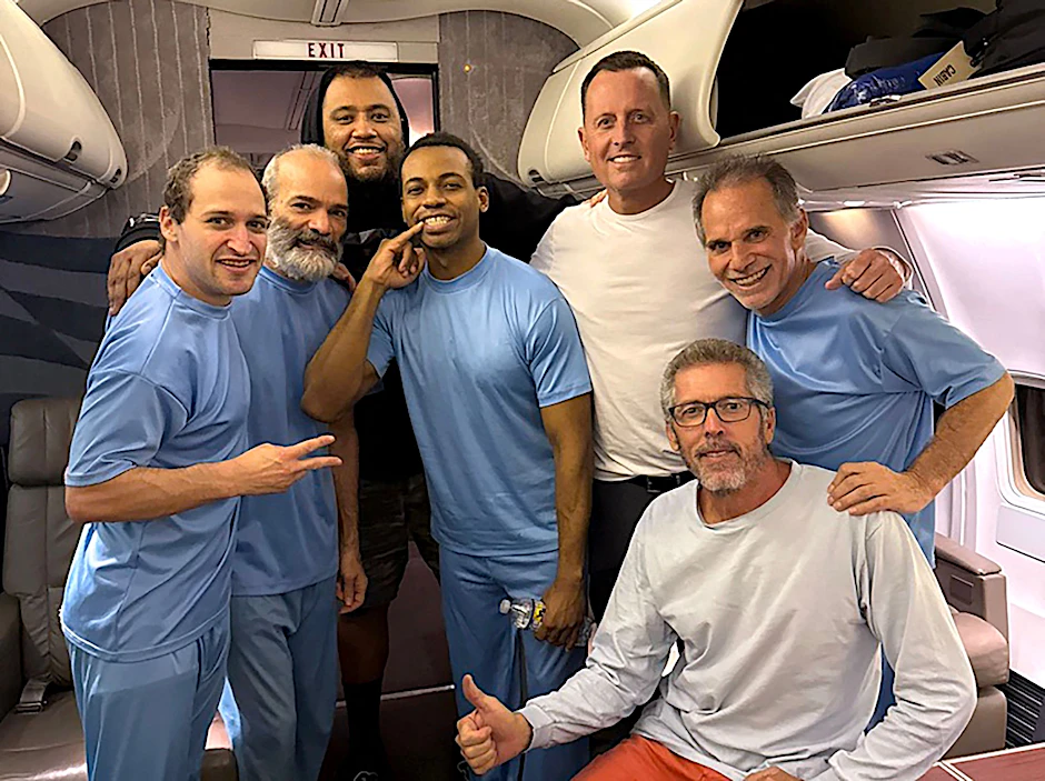 Richard Grenell (3. von rechts) an Bord eines Flugzeugs neben sechs in Venezuela freigelassenen US-Bürgern