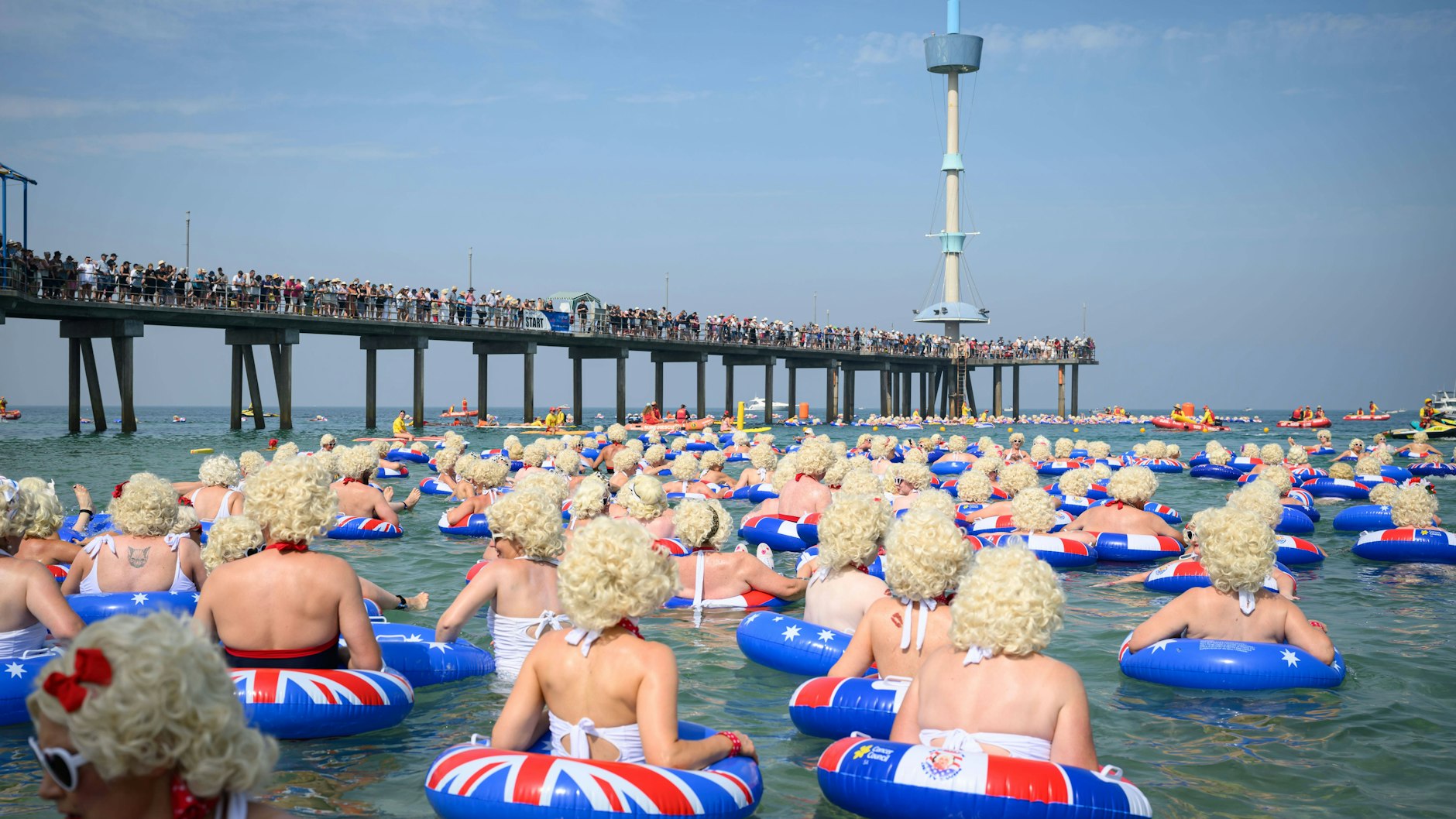 Die Marilyn-Monroe-Doubles schwimmen einmal um den Pier. Angefeuert von vielen Schaulustigen auf der Brücke.