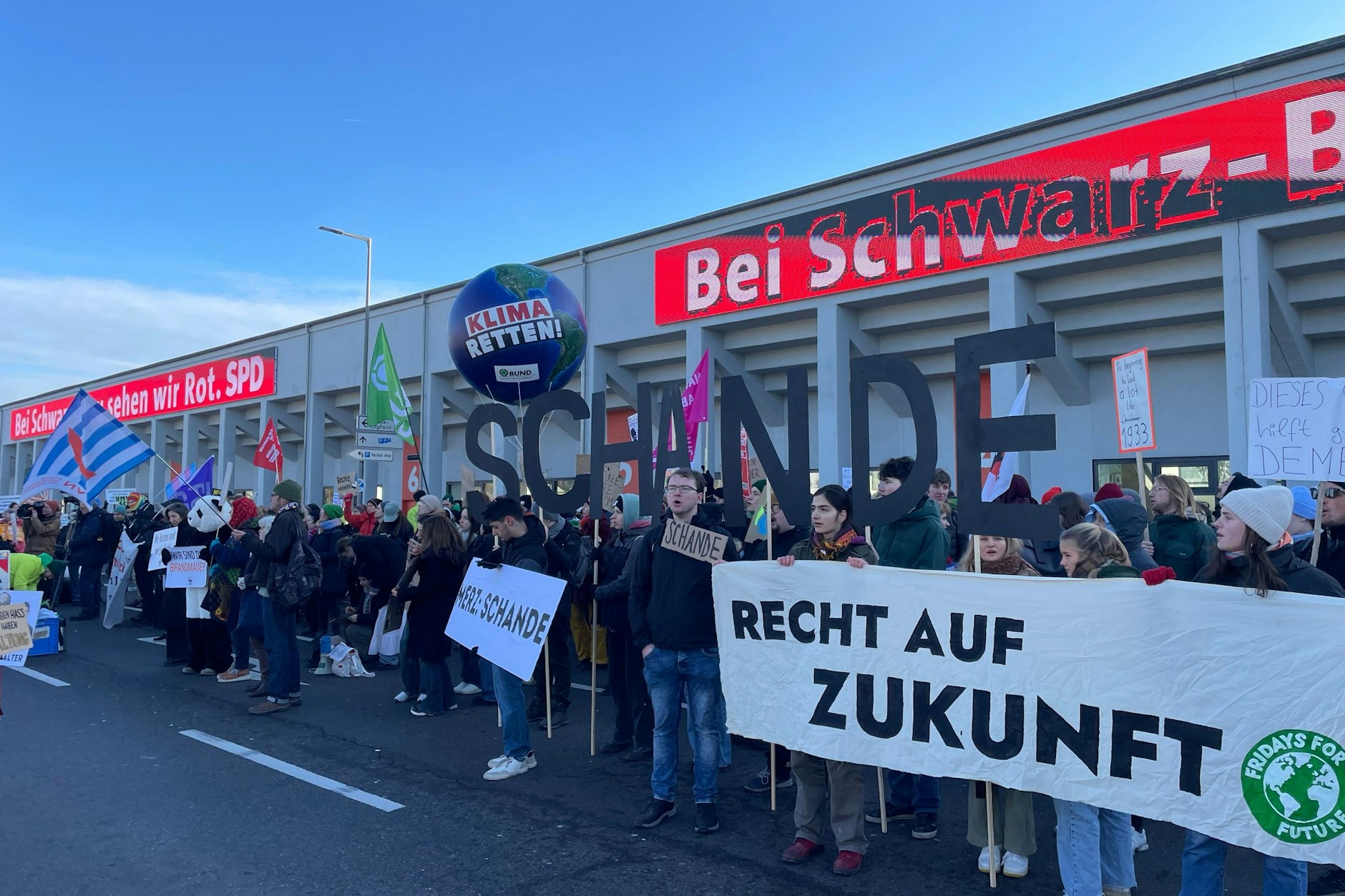 Auch das Wort „Schande“ ist bei dem Protest in großen schwarzen Lettern zu lesen.