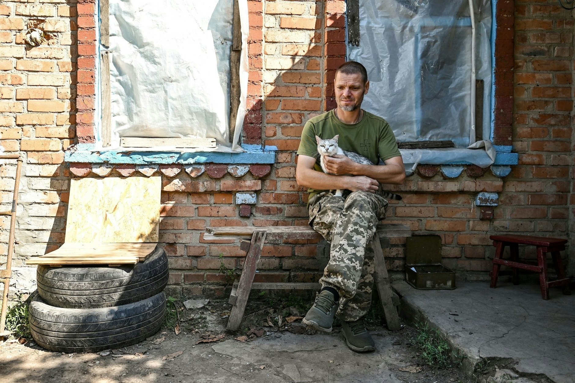 Ein Soldat der Territorialen Verteidigung der Ukraine aus Dnipro legt eine Pause ein – eine Katze leistet ihm Gesellschaft.