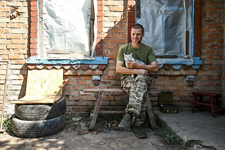 Ein Soldat der Territorialen Verteidigung der Ukraine aus Dnipro legt eine Pause ein – eine Katze leistet ihm Gesellschaft.