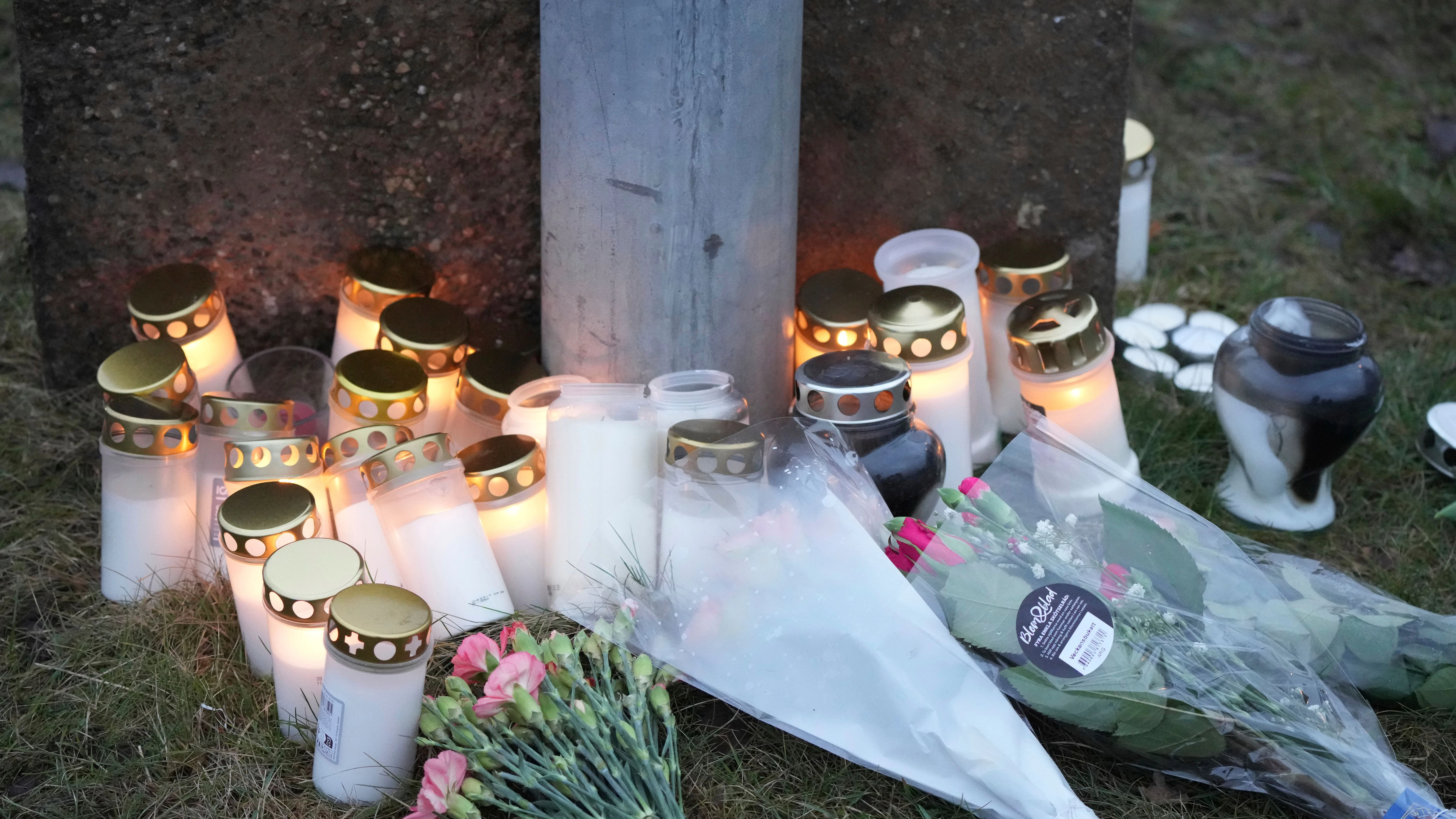 Menschen haben Kerzen und Blumen an einer behelfsmäßigen Gedenkstätte in der Nähe des Campus Risbergska am Rande von Örebro abgelegt.