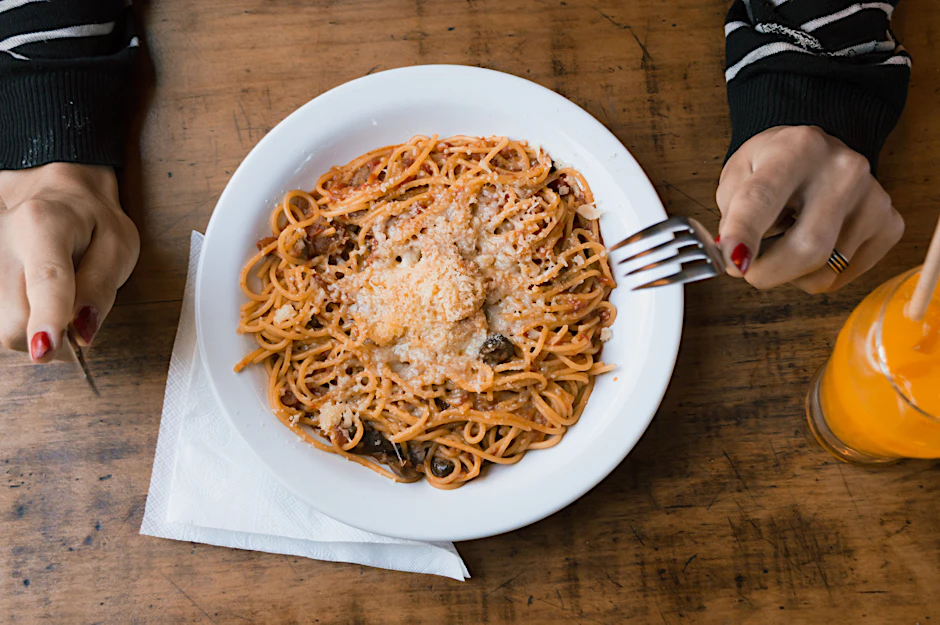In Friedrichshain-Kreuzberg wird in der Markthalle Neun eine lange Spaghetti-Tafel aufgebaut.