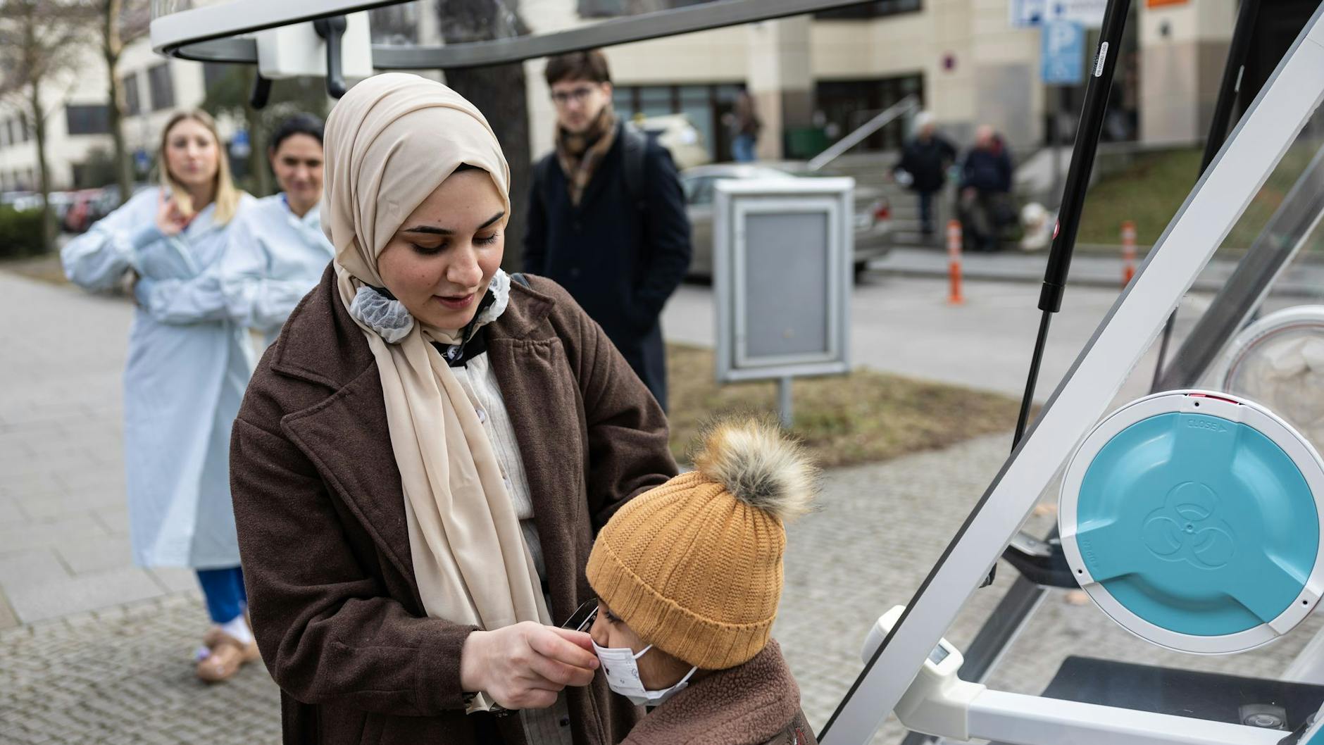Batoul Kanjo, Ahmads Mutter, richtet die Maske ihres Sohnes bevor er in das Ein-Personen-Fahrzeug „Moby“ einsteigt.