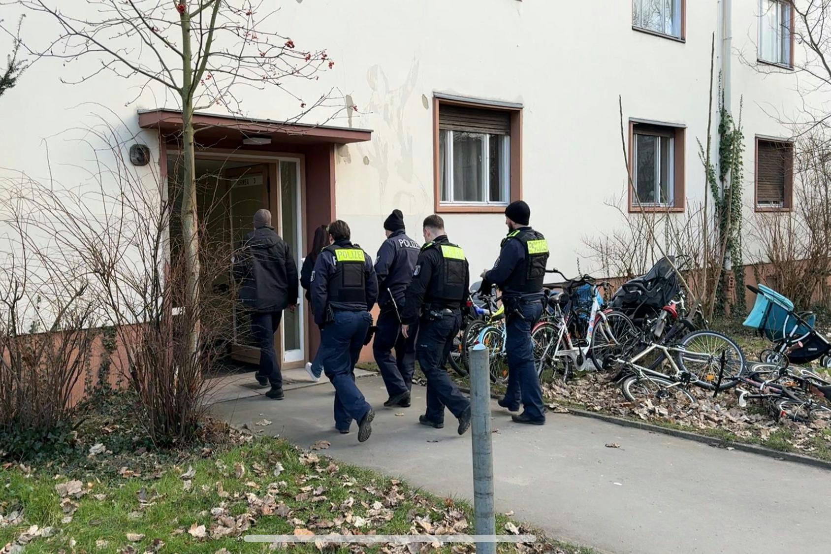 Einsatzkräfte der Polizei gehen in ein Haus. In einer Gemeinschaftsunterkunft für Flüchtlinge in Berlin-Marienfelde ist ein toter Mann entdeckt worden.