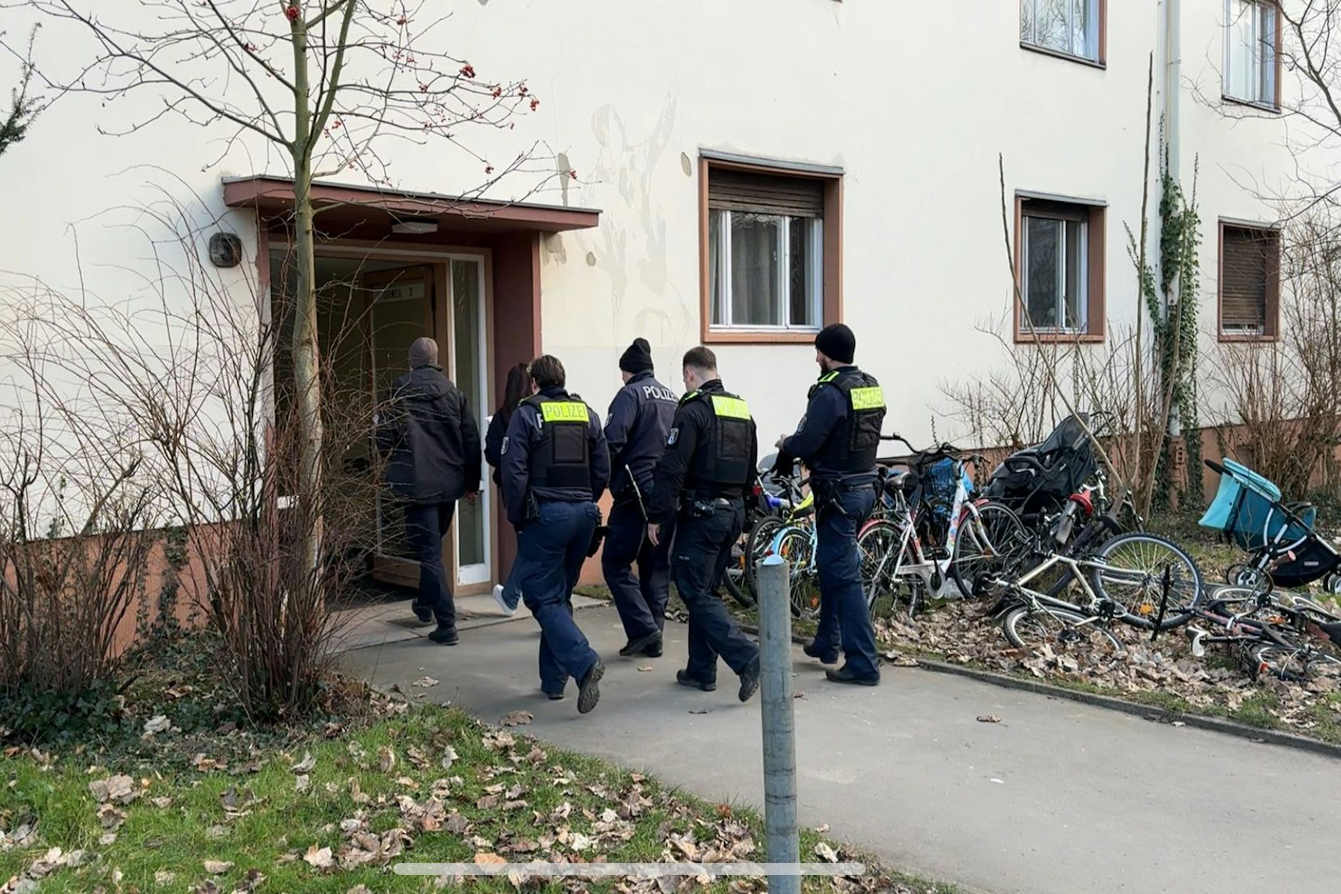 Einsatzkräfte der Polizei gehen in ein Haus. In einer Gemeinschaftsunterkunft für Flüchtlinge in Berlin-Marienfelde ist ein toter Mann entdeckt worden.