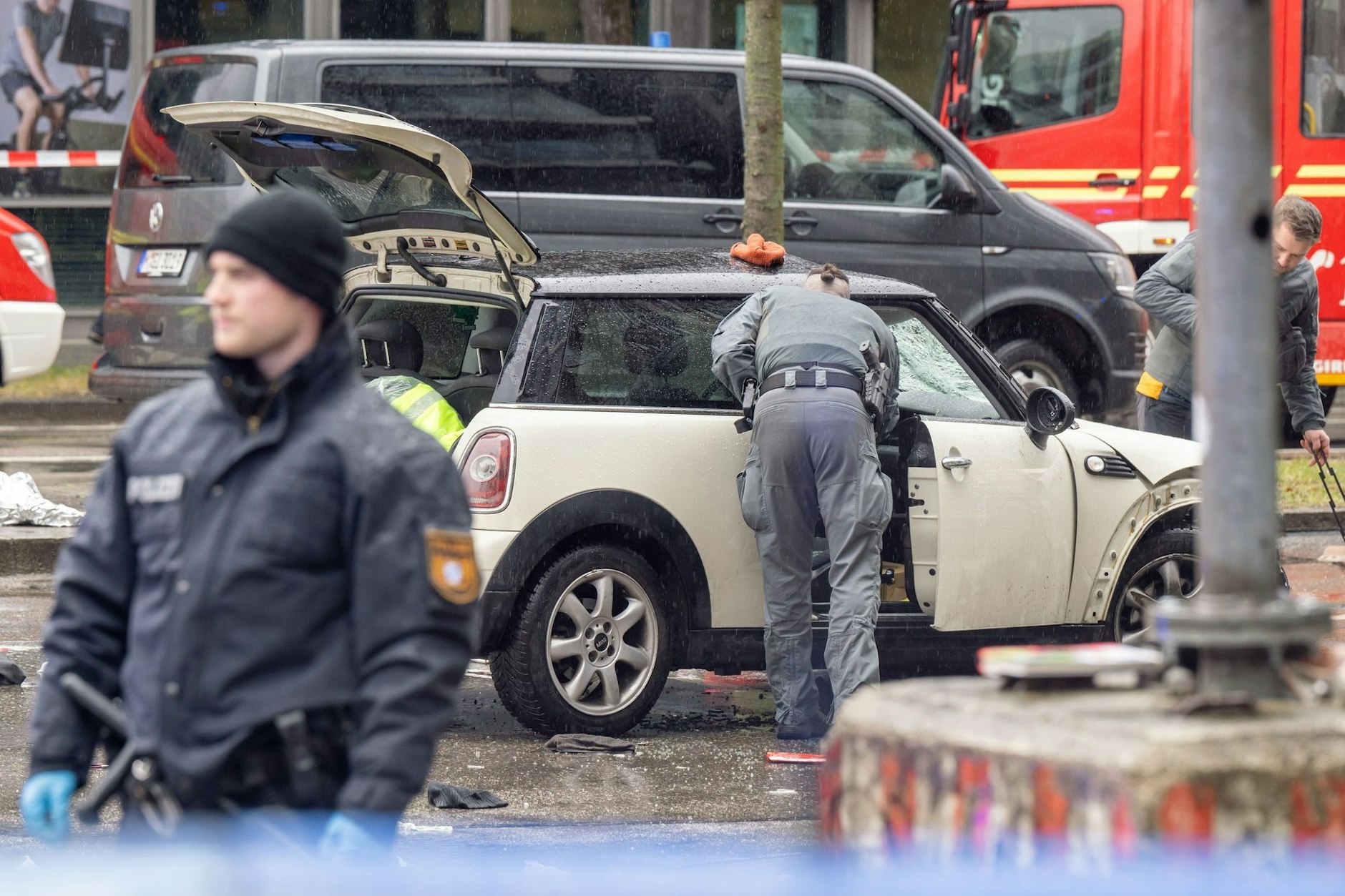Polizisten untersuchen ein Auto. In der Münchner Innenstadt ist ein Fahrzeug in eine Menschengruppe gefahren.