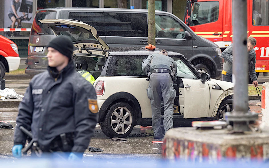 Polizisten untersuchen ein Auto. In der Münchner Innenstadt ist ein Fahrzeug in eine Menschengruppe gefahren.