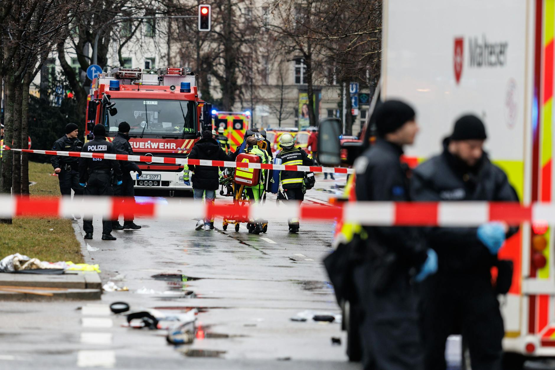 Rettungskräfte stehen in der Nähe des Einsatzortes. In der Münchner Innenstadt ist ein Fahrzeug in eine Menschengruppe gefahren.