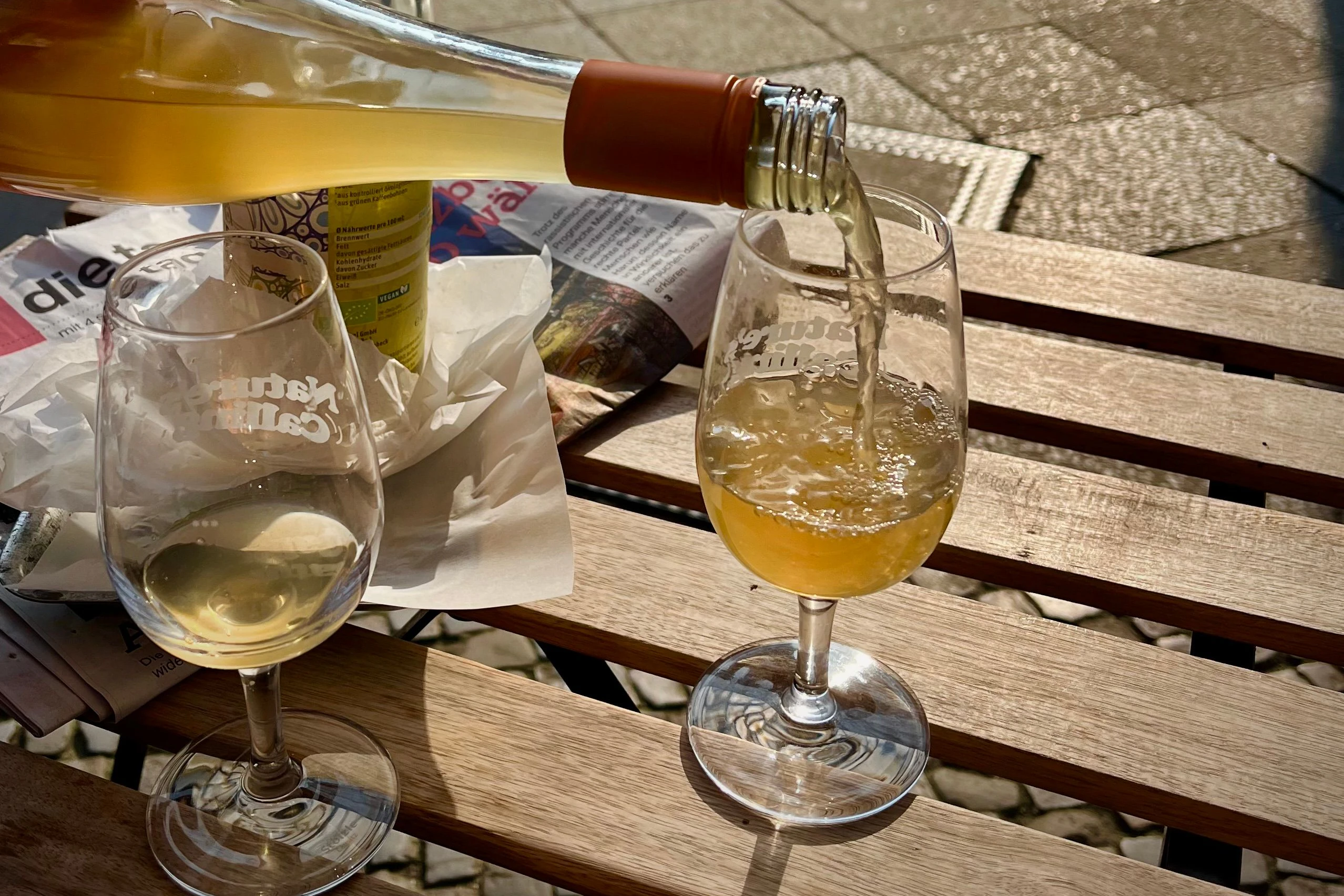Ein guter Tropfen Oranger Wein in der Frühlingssonne bei einem neuen Café der Stadt, Bagels &amp; Wein, in Neukölln. Sehr zu empfehlen.