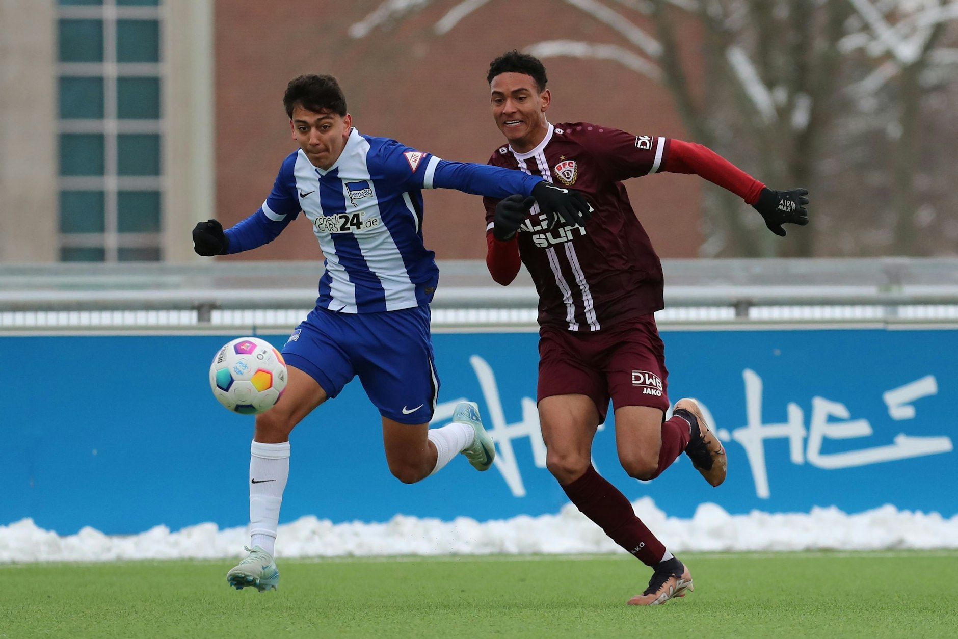 Grüner Rasen statt Schnee: Man sieht, dass auch Herthas Eliyas Strasner (l.) und BFC-Stürmer Benny Wüstenhagen da richtig Spaß haben.