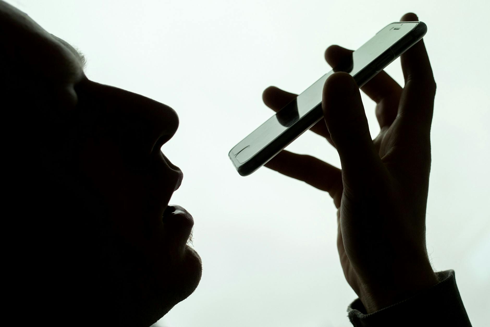 Ein Mann spricht in sein iPhone. Im Rechtsstreit um das mutmaßliche Mithören von Privatgesprächen seiner Nutzer durch seinen Sprachassistenten Siri hat Apple einer Zahlung von 95 Millionen Dollar (92 Millionen Euro) zugestimmt.