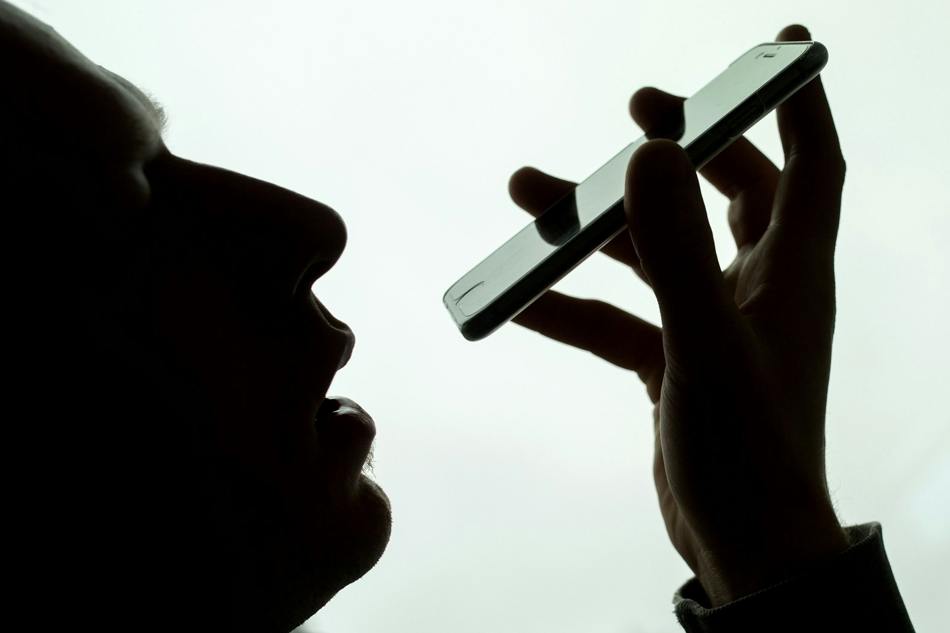 Ein Mann spricht in sein iPhone. Im Rechtsstreit um das mutmaßliche Mithören von Privatgesprächen seiner Nutzer durch seinen Sprachassistenten Siri hat Apple einer Zahlung von 95 Millionen Dollar (92 Millionen Euro) zugestimmt.