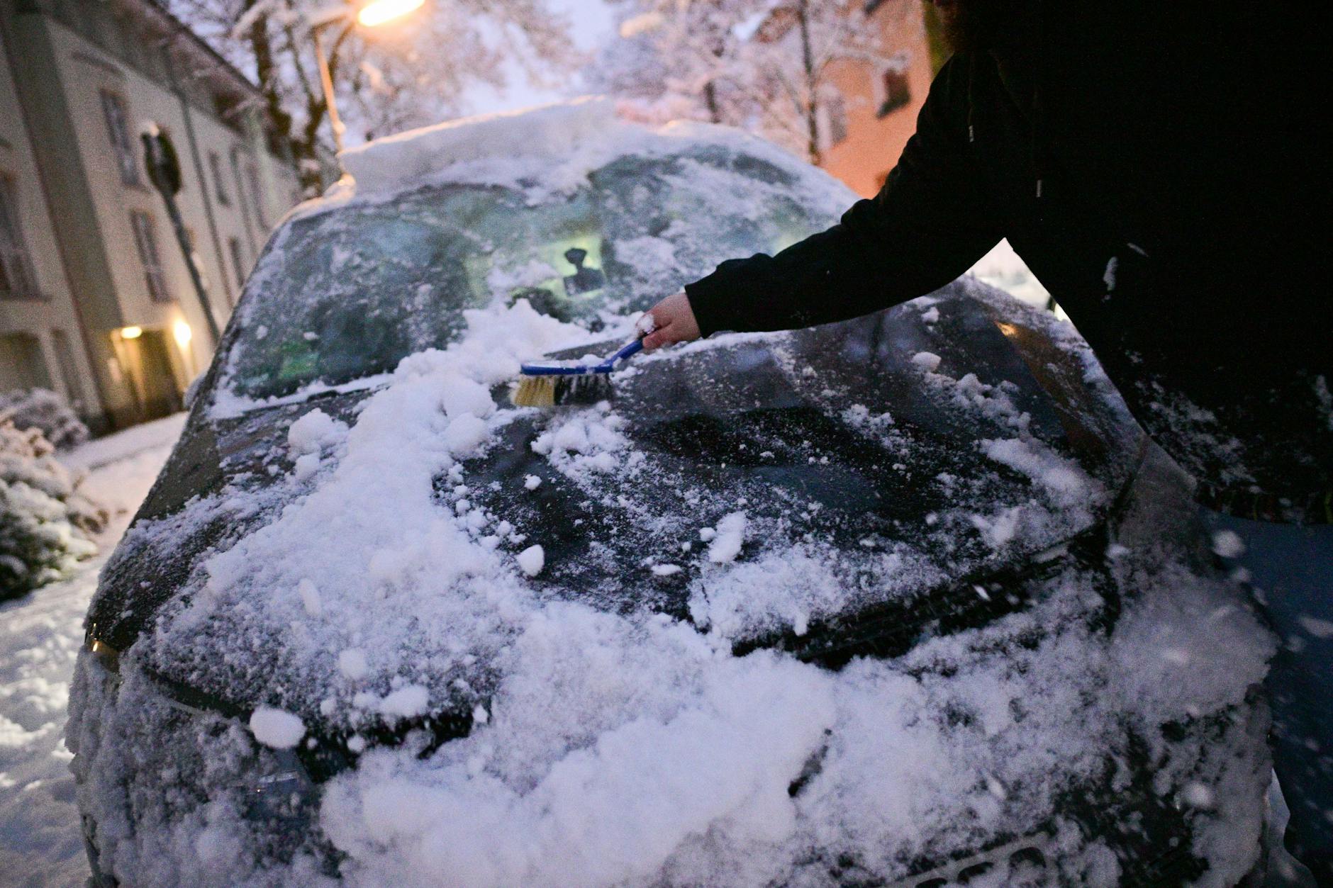Ein Mann befreit sein Auto von Schnee in Berlin. So heftiges Winterwetter wie am Freitagmorgen gibt es in der Hauptstadt selten.