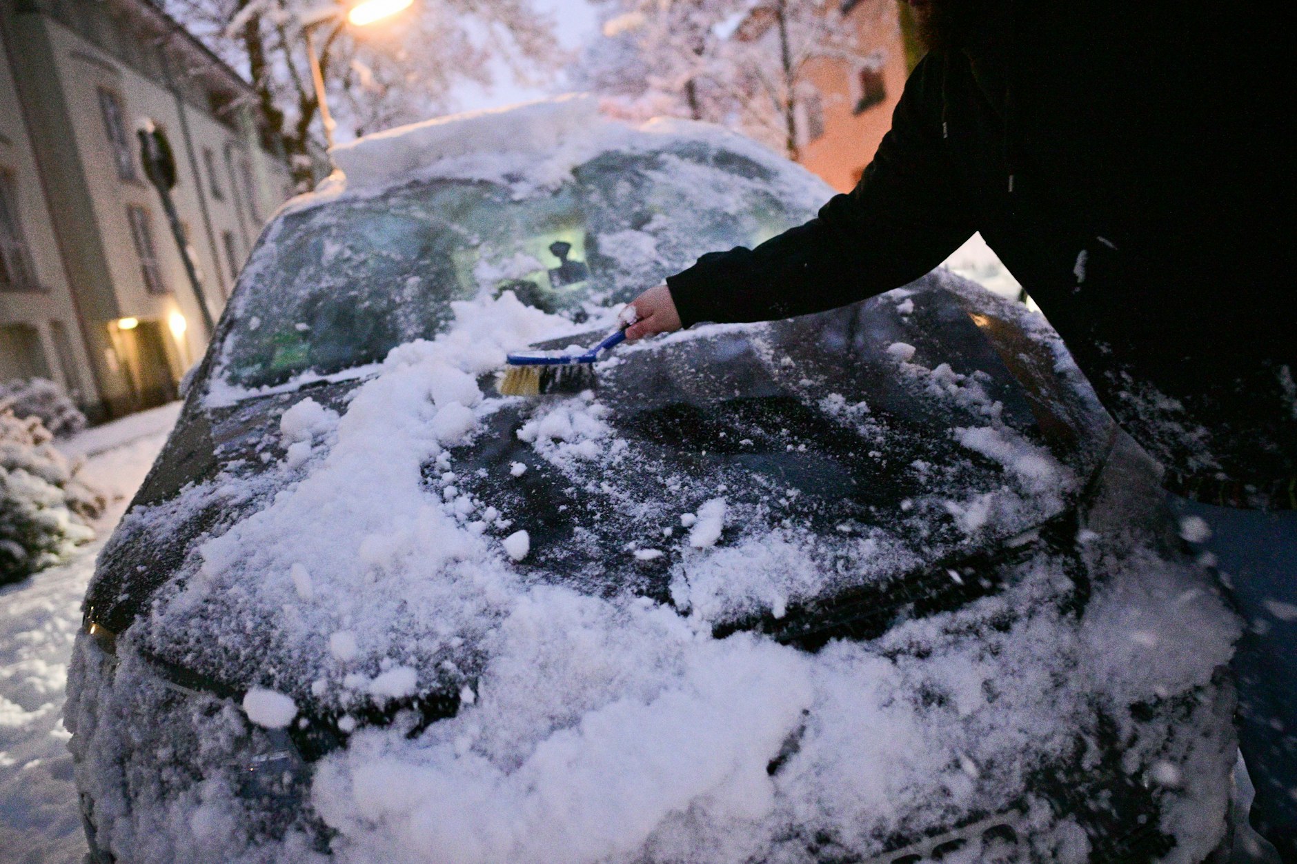 Ein Mann befreit sein Auto von Schnee in Berlin. So heftiges Winterwetter wie am Freitagmorgen gibt es in der Hauptstadt selten.