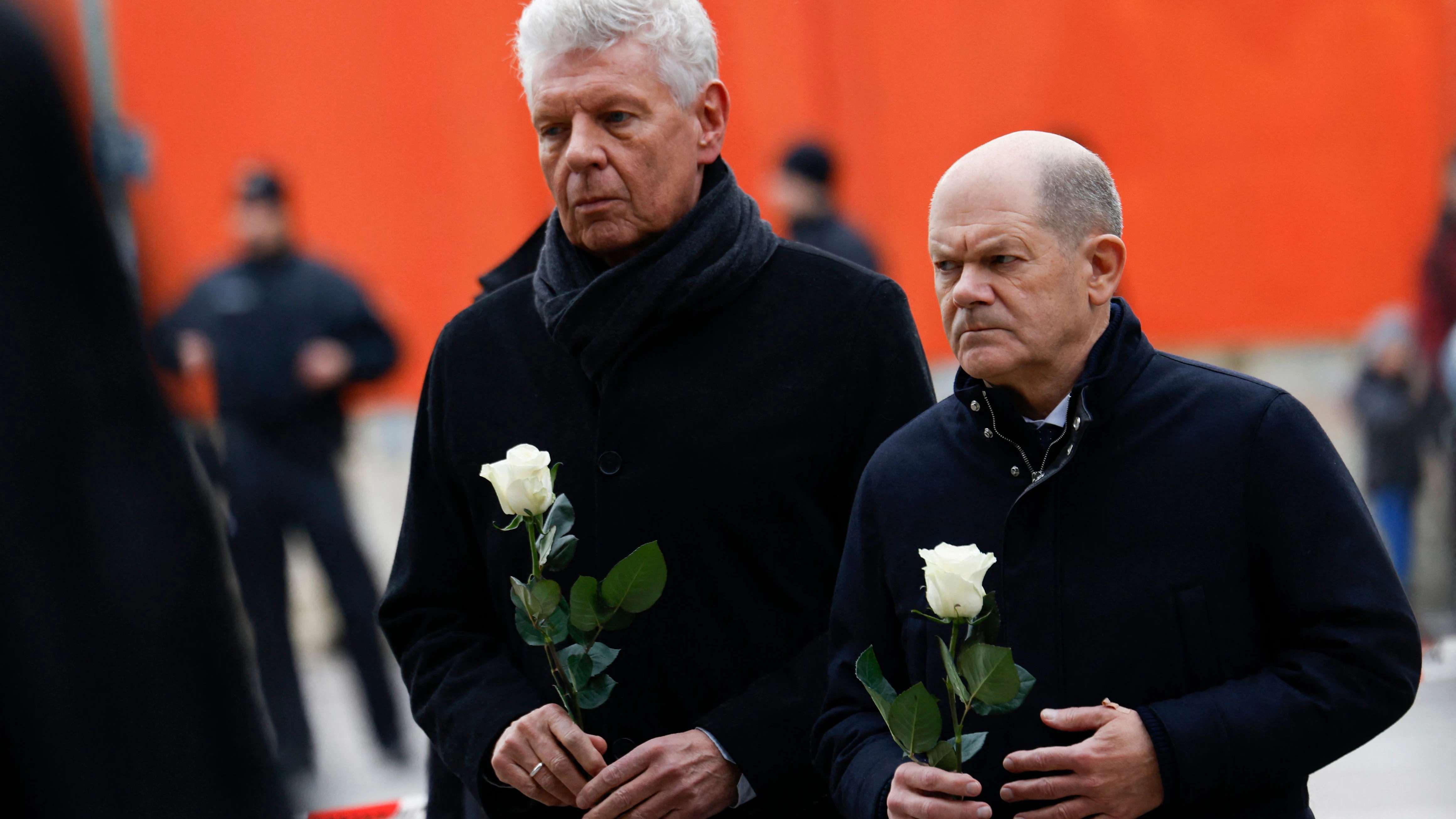 Bürgermeister Dieter Reiter und Bundeskanzler Olaf Scholz legen am Ort des Anschlags weiße Rosen nieder.