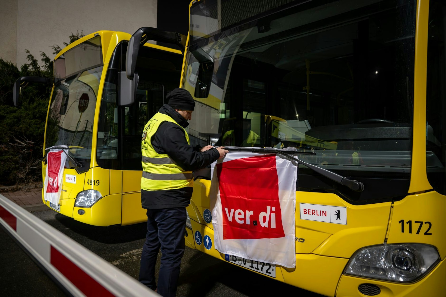Zeichen stehen auf Warnstreik: Verdi-Mitglied Manuel von Stubenrauch befestigt während eines Ausstandes die Fahnen der Gewerkschaft an den Scheibenwischern der Busse, die im Depot bleiben.