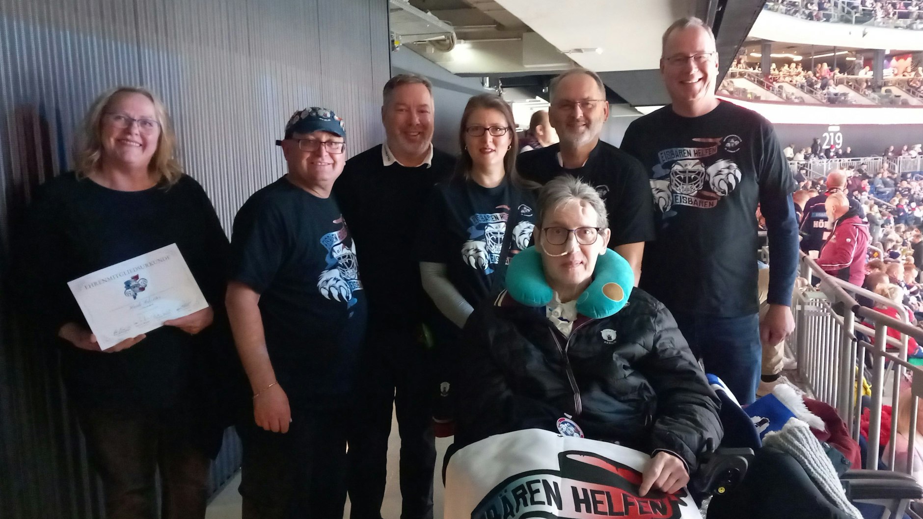 Ehefrau Heidi (l.) zeigt stolz die Ehrenmitglieds-Urkunde, Eisbären-Boss Thomas Bothstede (3.v.l.) ist auch dabei und der „EHE“-Vorstand mit Peter Breitenberger (2.v.l.) sowie (v.r.) Christian Wittrock, Kai-Uwe Hempel und Claudia Ehrchen freuen sich, dass Ingo Schröter in der Halle ist.