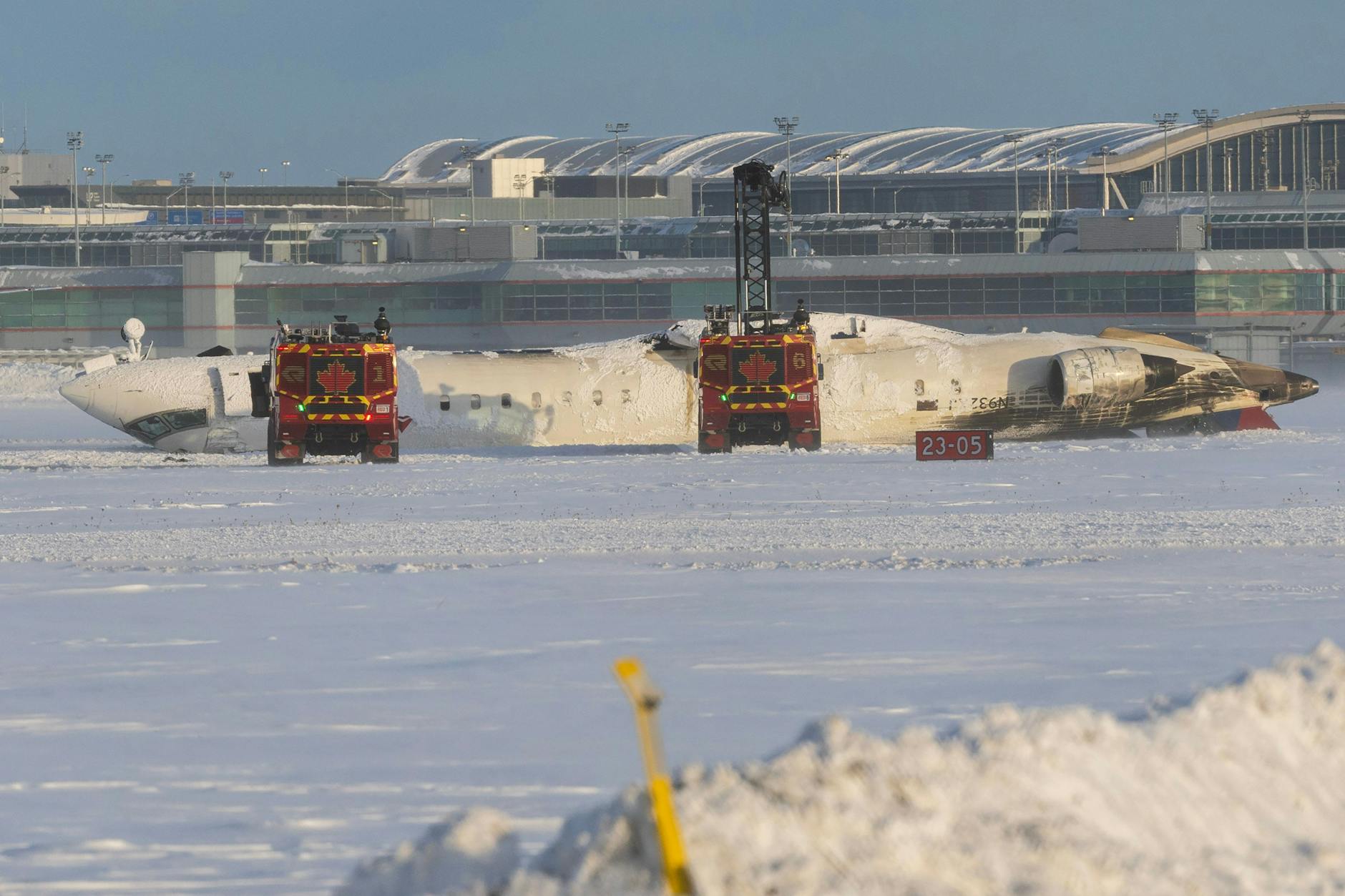 Kopfüber liegt die Maschine auf dem Flughafen in Toronto. Die Feuerwehr ist vor Ort.