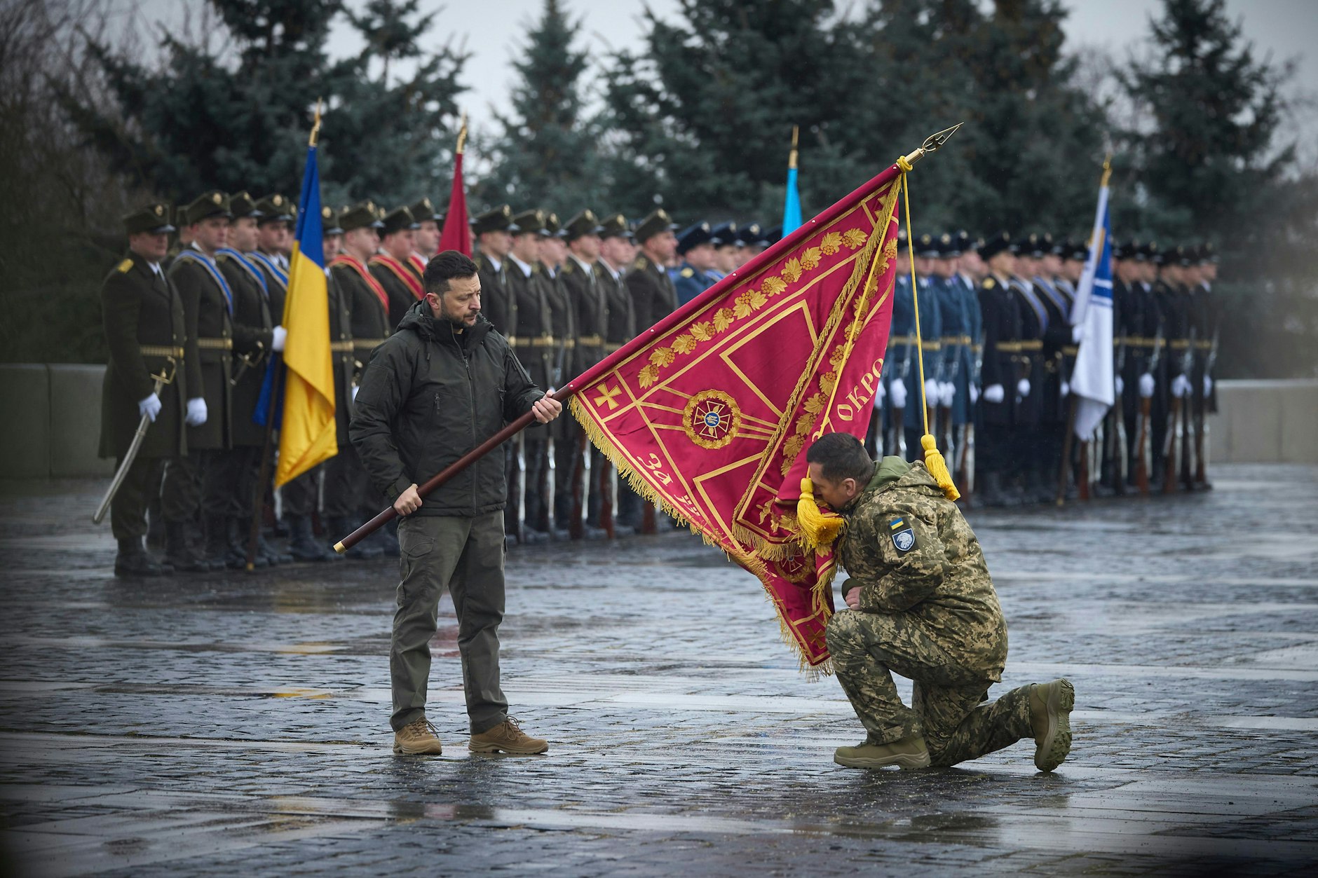 Der ukrainische Präsident Wolodymyr Selenskyj hält eine Kampfflagge, die ein Soldat während einer Auszeichnung küsst. Das Vertrauen in den Präsidenten ist seit Kriegsbeginn stark gesunken.