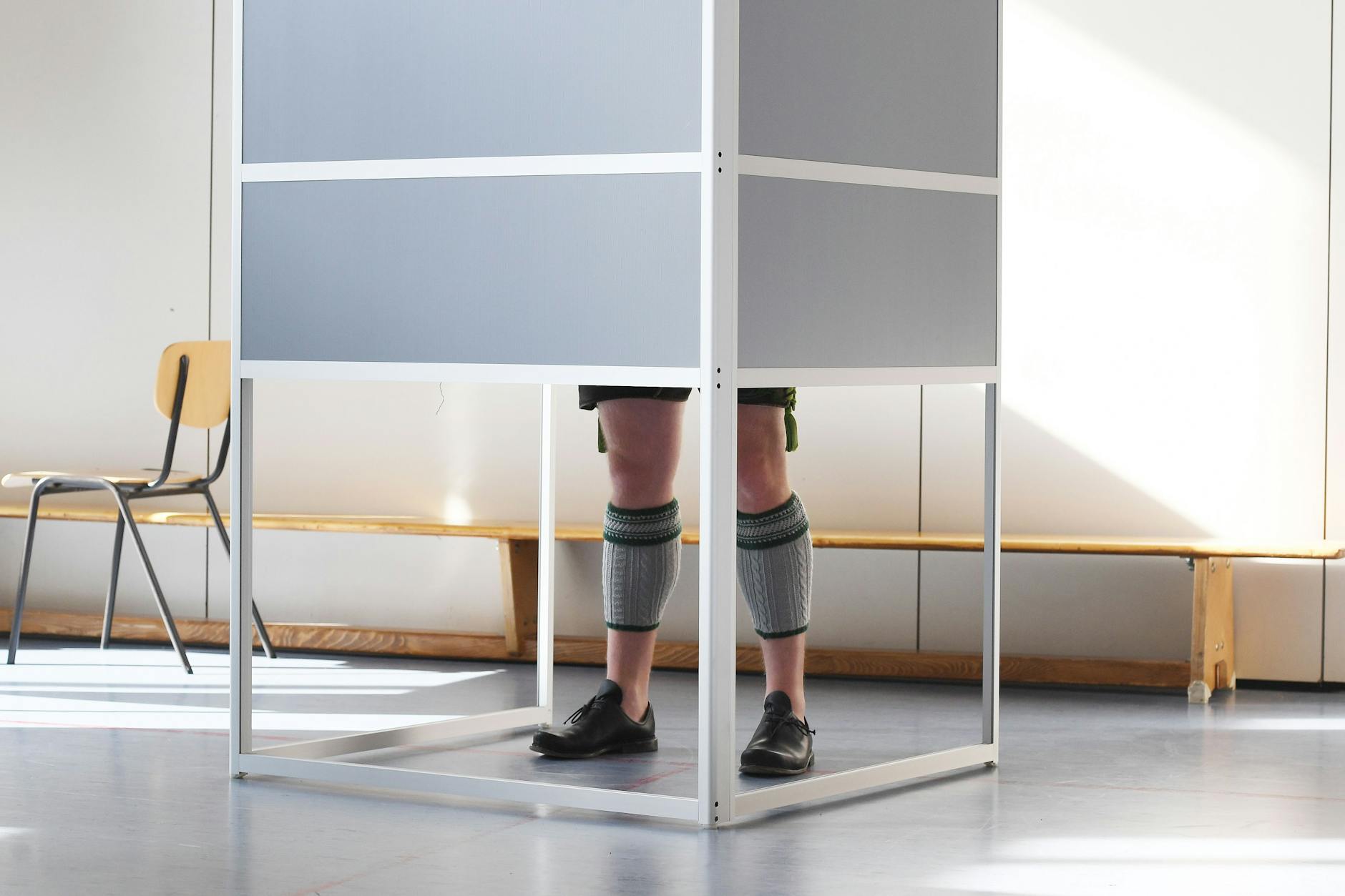 Eine Wahlkabine im bayerischen Garmisch-Partenkirchen: Ein Mann in bayerischer Tracht gibt seine Stimme für die Bundestagswahl in einem Wahllokal ab.