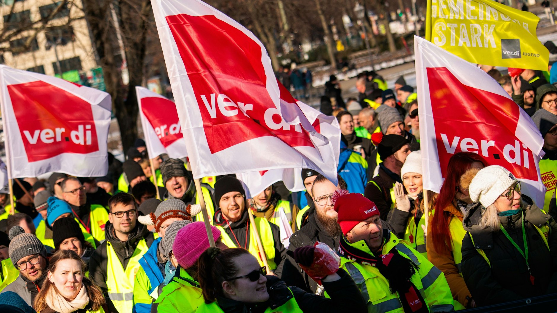 Mitglieder verschiedener Berufsgruppen halten Verdi-Fahnen bei einer Kundgebung der Dienstleistungsgewerkschaft Verdi vor dem Roten Rathaus.
