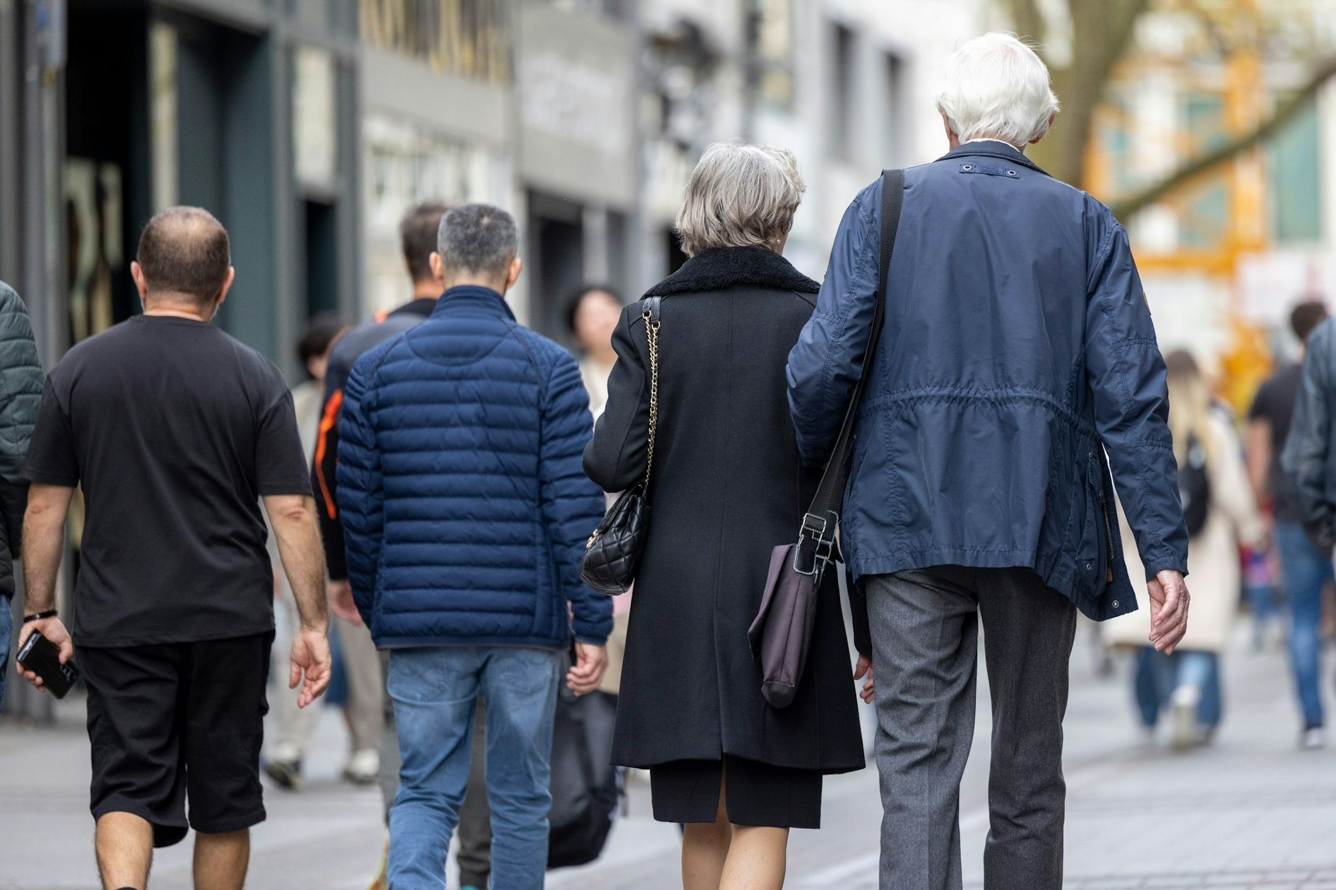 Senioren gehen durch Innenstadt.