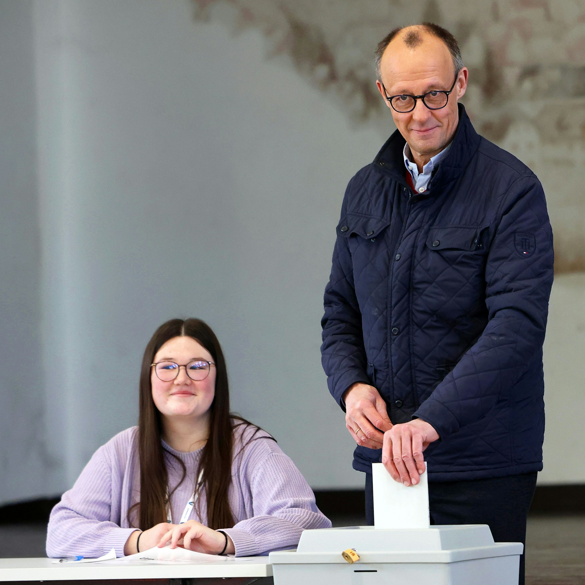 Friedrich Merz (CDU, r.), Parteivorsitzender und Kanzlerkandidat, gibt im Wahllokal in der Schützenhalle Arnsberg-Niedereimer seine Stimme ab.
