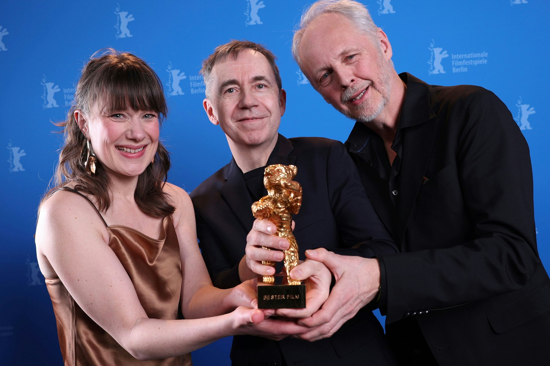 Der Regisseur und Drehbuchautor Dag Johan Haugerud (Mitte) sowie die Produzenten Yngve Saether und Hege Hauff Hvattumon zeigen stolz ihren Goldenen Bären für den Film „Drømmer“.