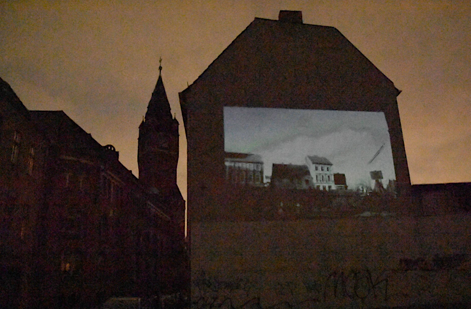 Stromausfall in Berlin-Köpenick nach Bauarbeiten an der Allende-Brücke, im Bild: Oliver Polsfuß von der Radschmiede Berlin in Alt-Köpenick nutzte die Dunkelheit aus, er warf Fotos mit alten Postkarten von Köpenick an eine Häuserwand am Hochzeitsparkplatz, im Hintergrund das Rathaus Köpenick, 19.02. 2019,