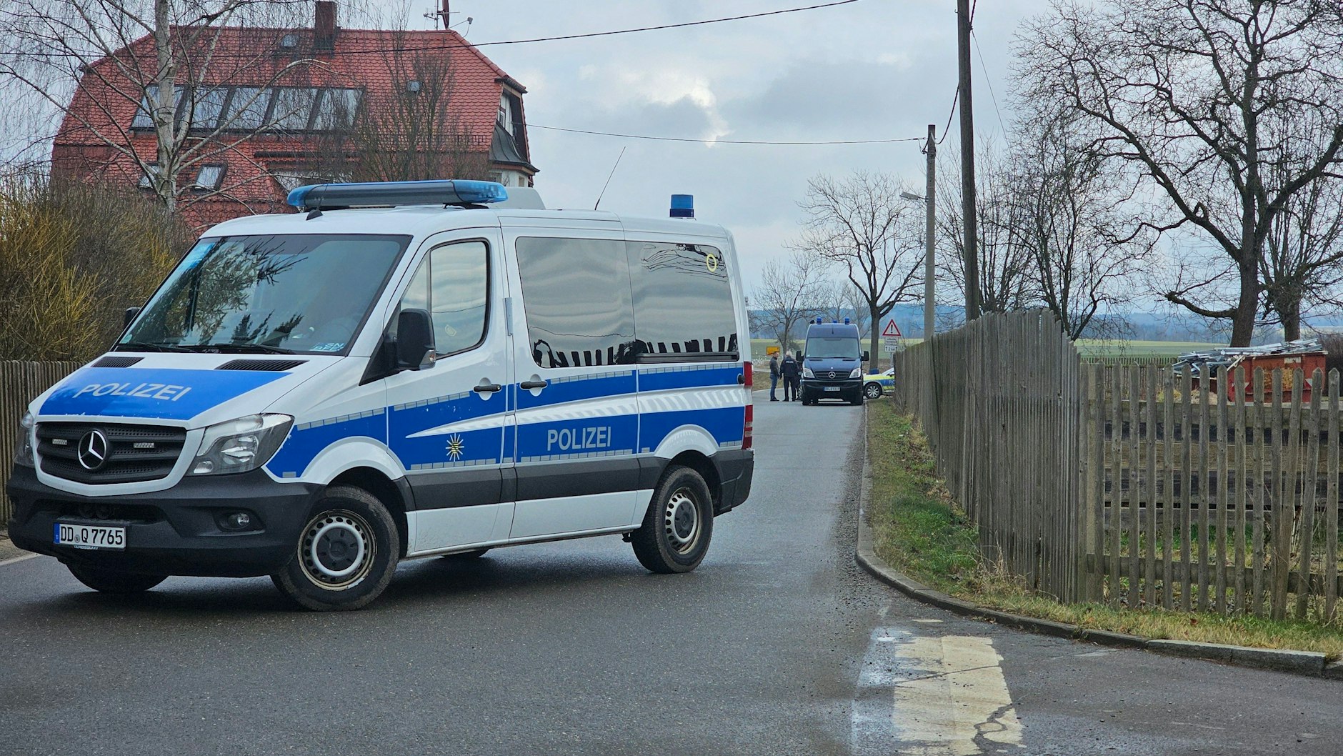 Ein Polizeiwagen hat den Tatort zugesperrt. Hier wurden drei Leichen gefunden.